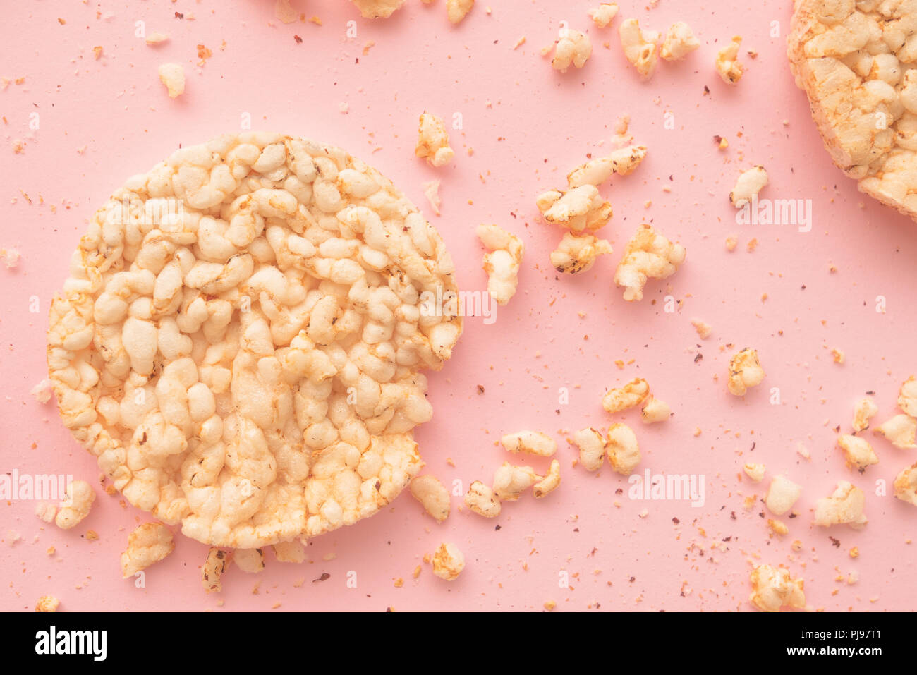 Lay piatto croccante e torte di riso pastello su sfondo rosa, overhead vista dall'alto in basso Foto Stock