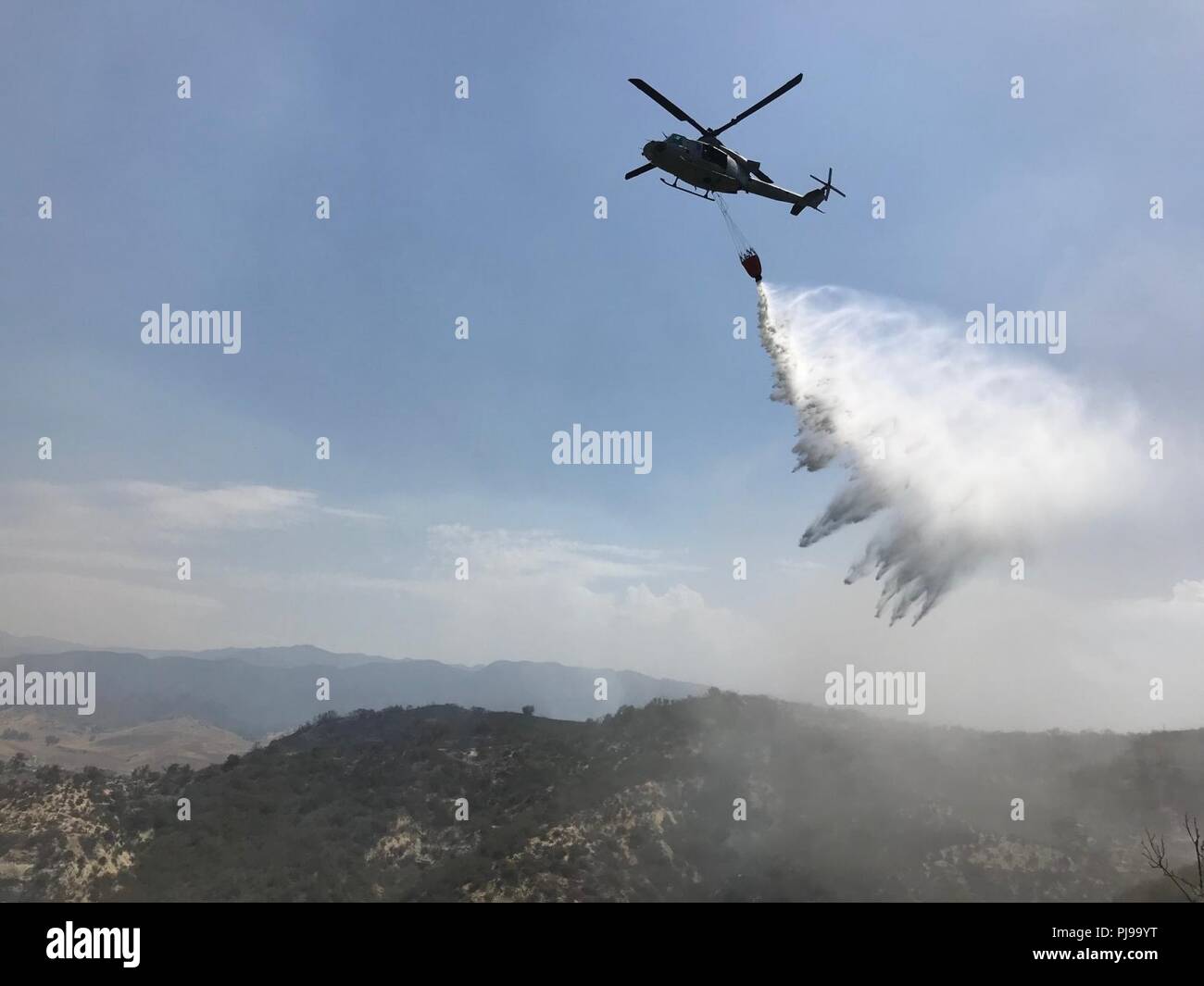 Marines con Marine Attacco leggero elicottero Squadron (HMLA) 267 e HMLA-169, Marine Aircraft Group (MAG) 39, terzo aeromobile Marina Wing, condotta secchio di acqua scende oltre una spazzola fire a sostegno delle operazioni di estinzione al Marine Corps base Camp Pendleton, California, il 6 luglio. Il "Pendleton complesso", costituito da tre distinti incendi, bruciato quasi 2.000 acri. In tutti, di sei aeromobili dal 3 MAW condotta quasi 250 gocce d'acqua su due distinti incendi in 30 ore. Foto Stock