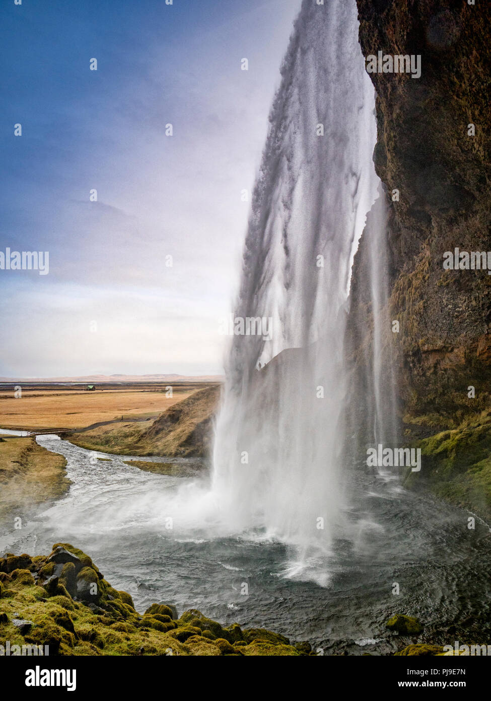 22 Aprile 2018: Sud Islanda - Seljalandsfoss cascata. Due persone possono solo essere veduto camminare sulla roccia dietro la cascata. Foto Stock
