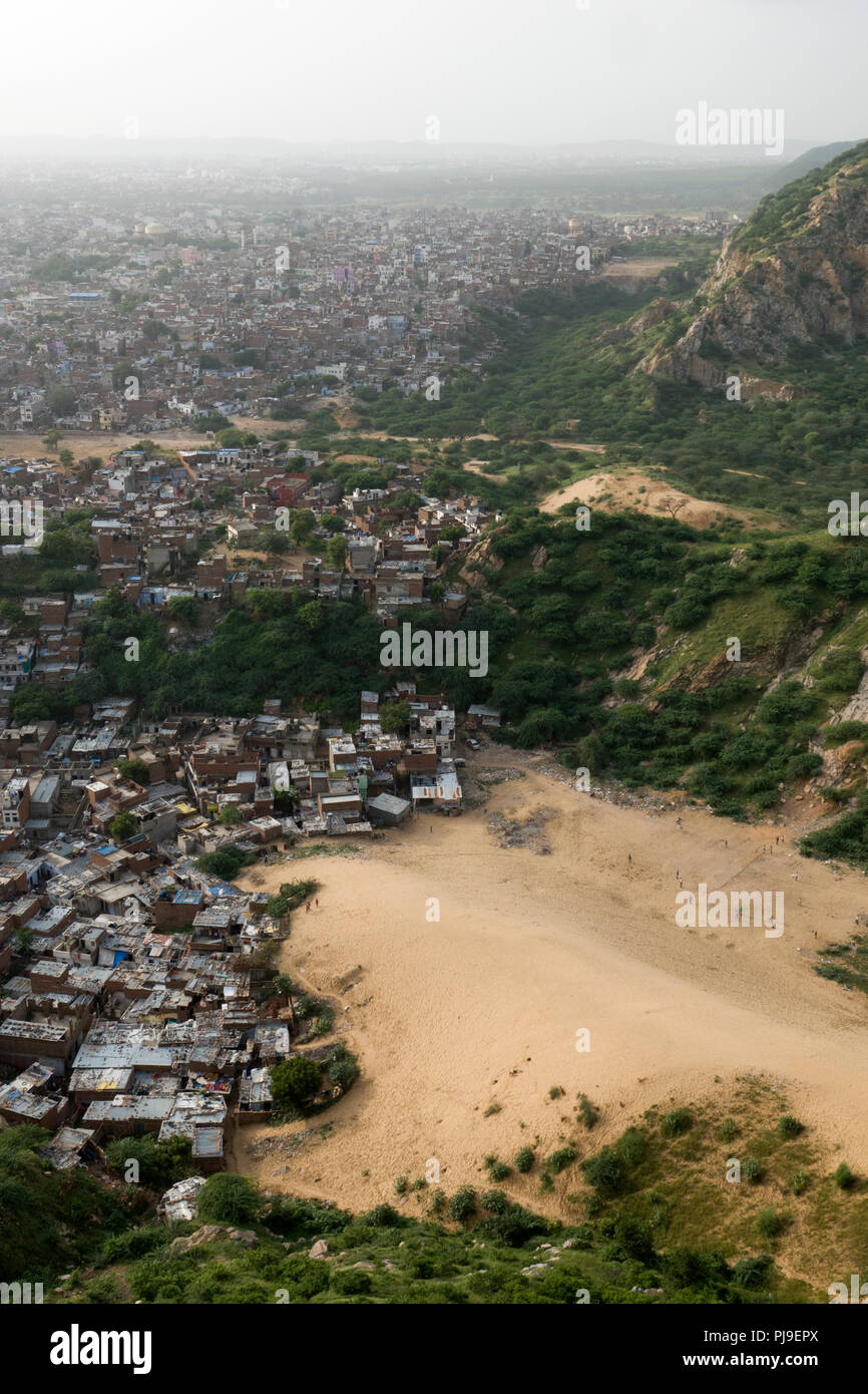 Baraccopoli zona accanto alle dune di sabbia a base di Colli Aravalli a Jaipur, Rajasthan, India Foto Stock