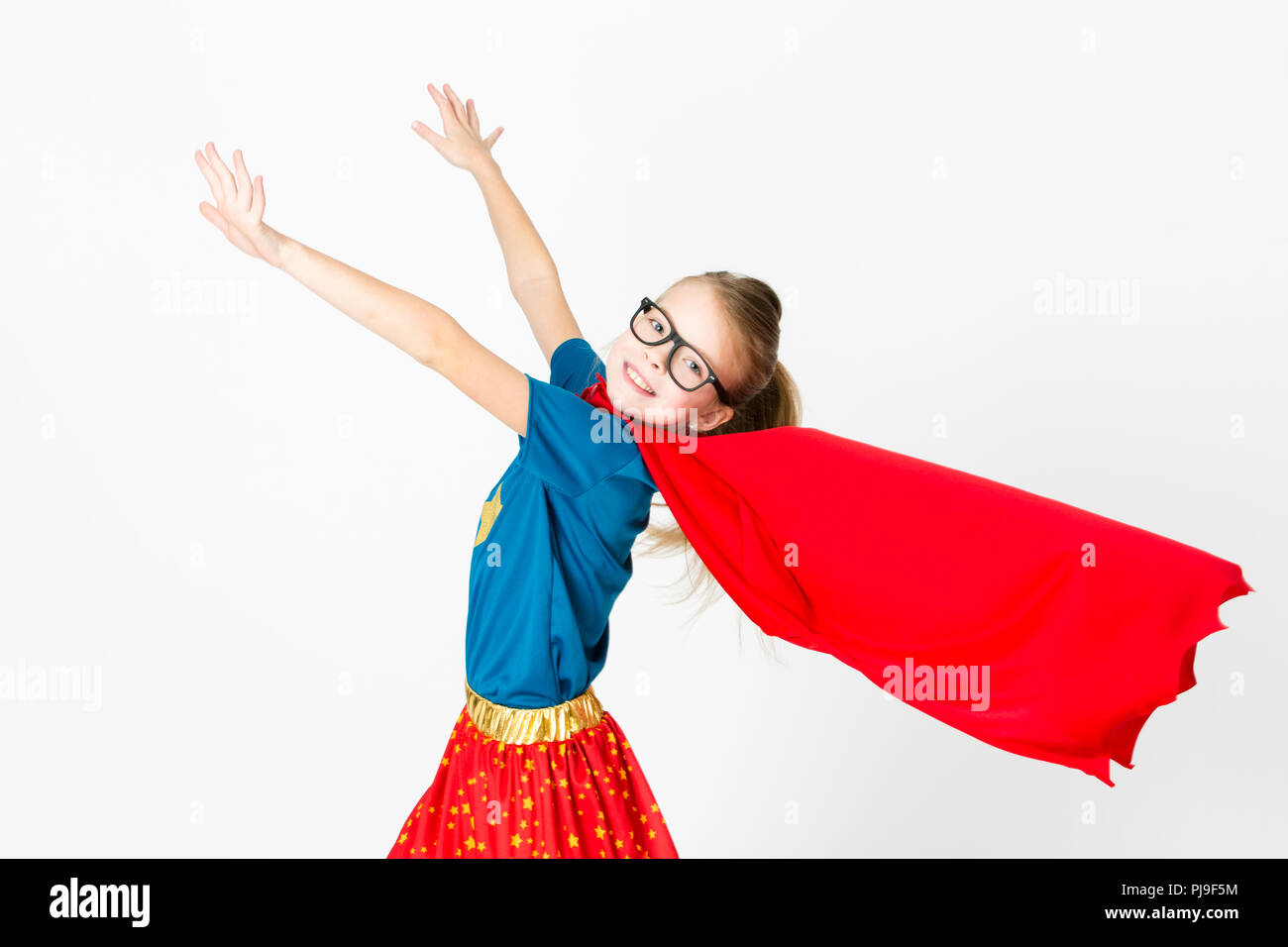 Supergirl biondo con gli occhiali e abito rosso und maglietta blu è in posa in studio Foto Stock