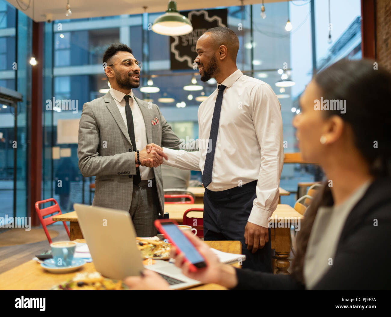 Imprenditori handshake, lavorando in cafe Foto Stock