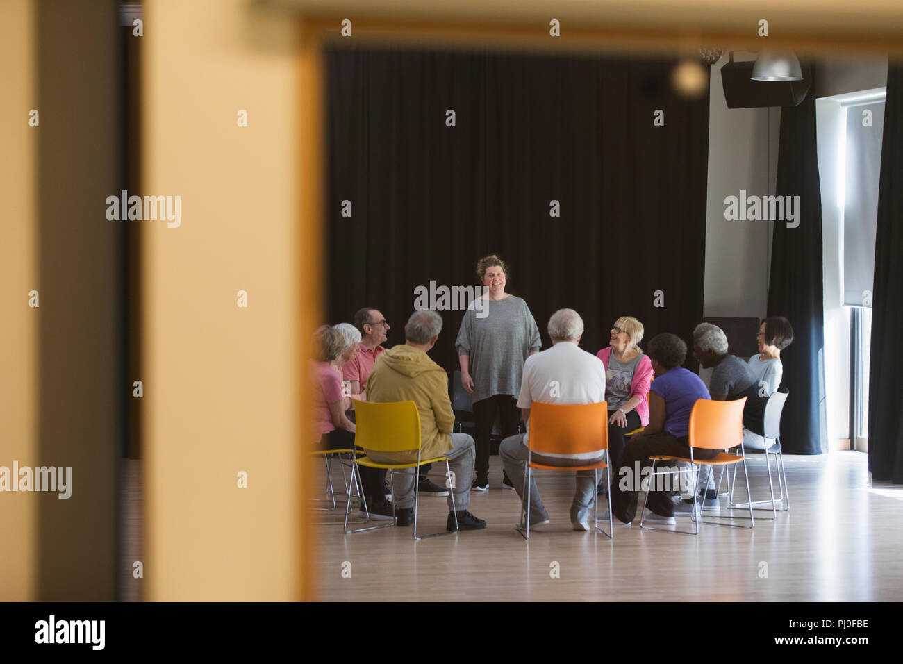 Donna che portano gli anziani nella discussione di gruppo in centro nella comunità Foto Stock