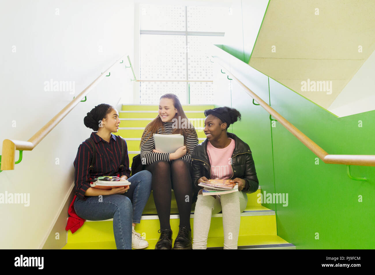 Alta scuola ragazze parlando su scale Foto Stock