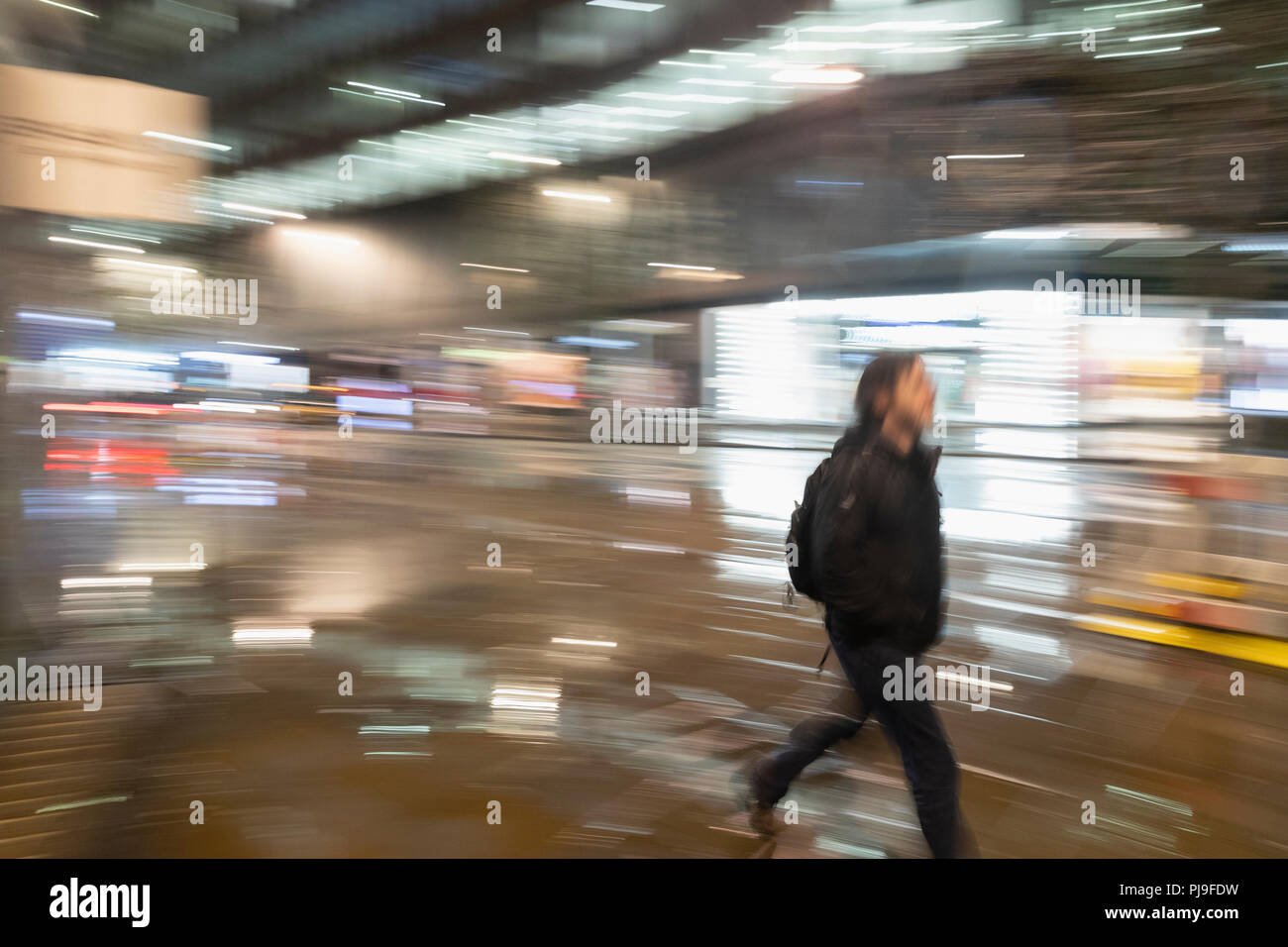 Uomo che cammina sulla strada urbana di notte Foto Stock