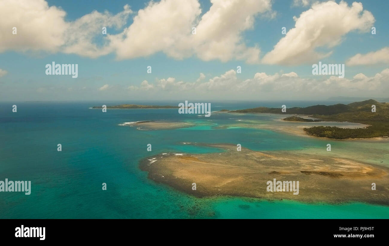 Vista aerea: spiaggia, isola tropicale, Baia Mare e laguna, Siargao. Paesaggio tropicale hill, nuvole e montagne rocce con la foresta pluviale. Acque azzurre della laguna. Paesaggio Shore Bay. Video dell'antenna.Seascape. Foto Stock