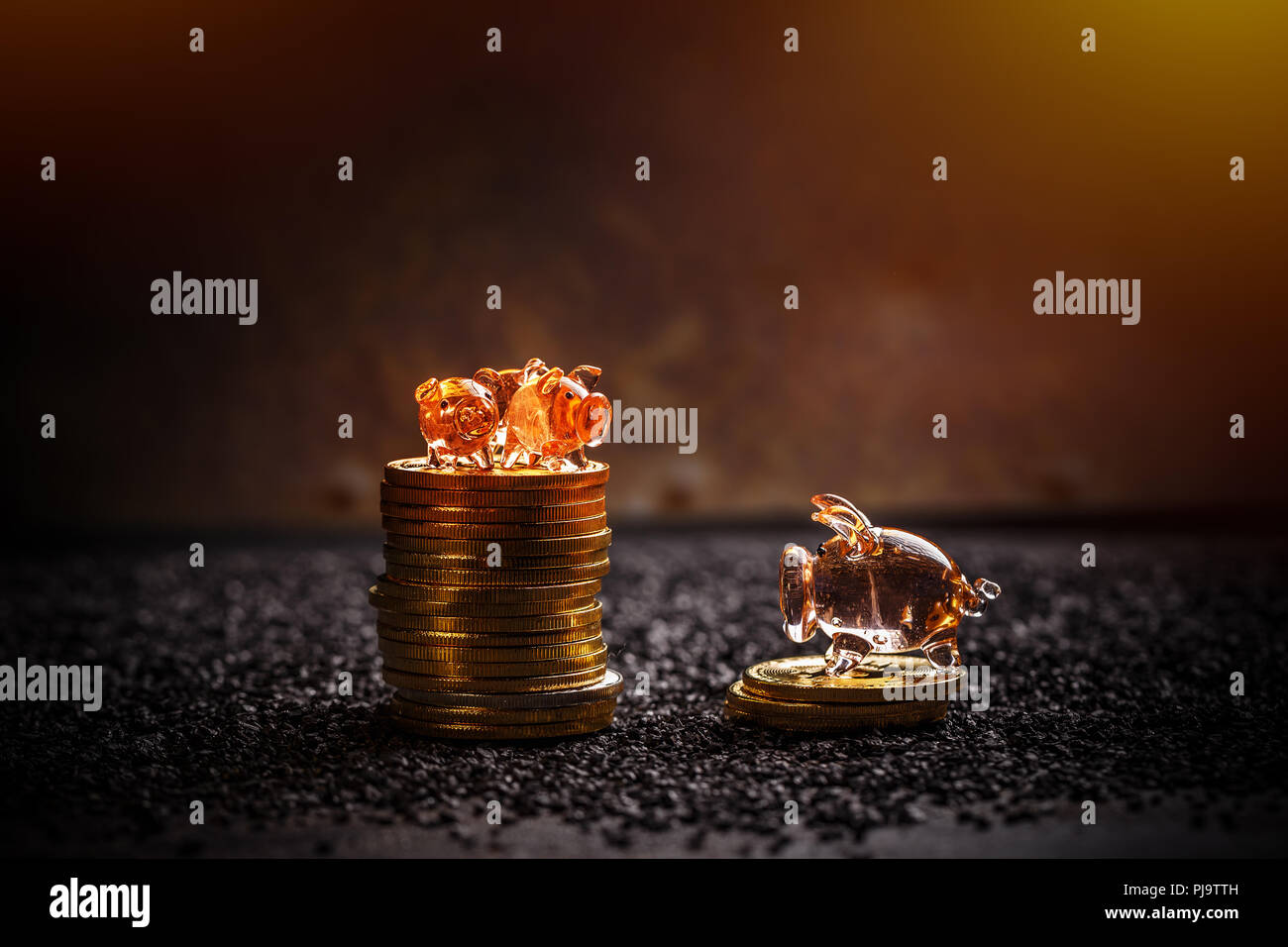Golden bitcoins giacciono in un palo con poco piggy su sfondo scuro Foto Stock