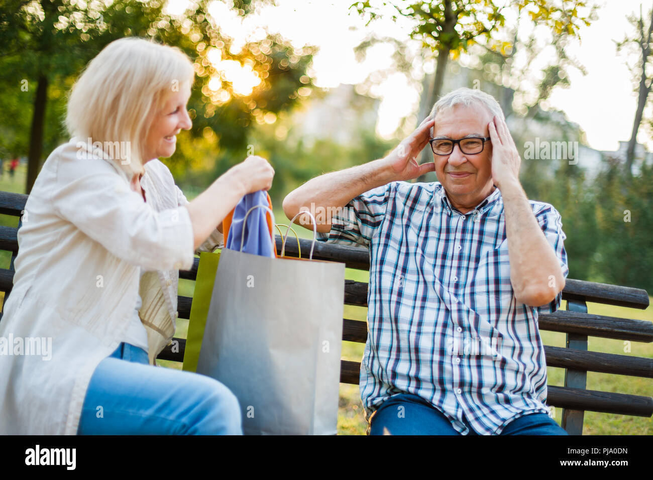 Senior l uomo è arrabbiato perché la sua donna è di spendere soldi su vestiti. Foto Stock