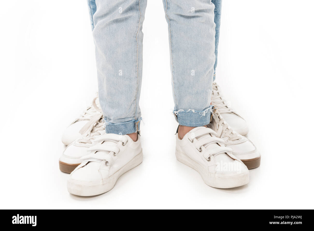 Vista parziale di famiglia in jeans e scarpe bianco isolato su bianco Foto Stock