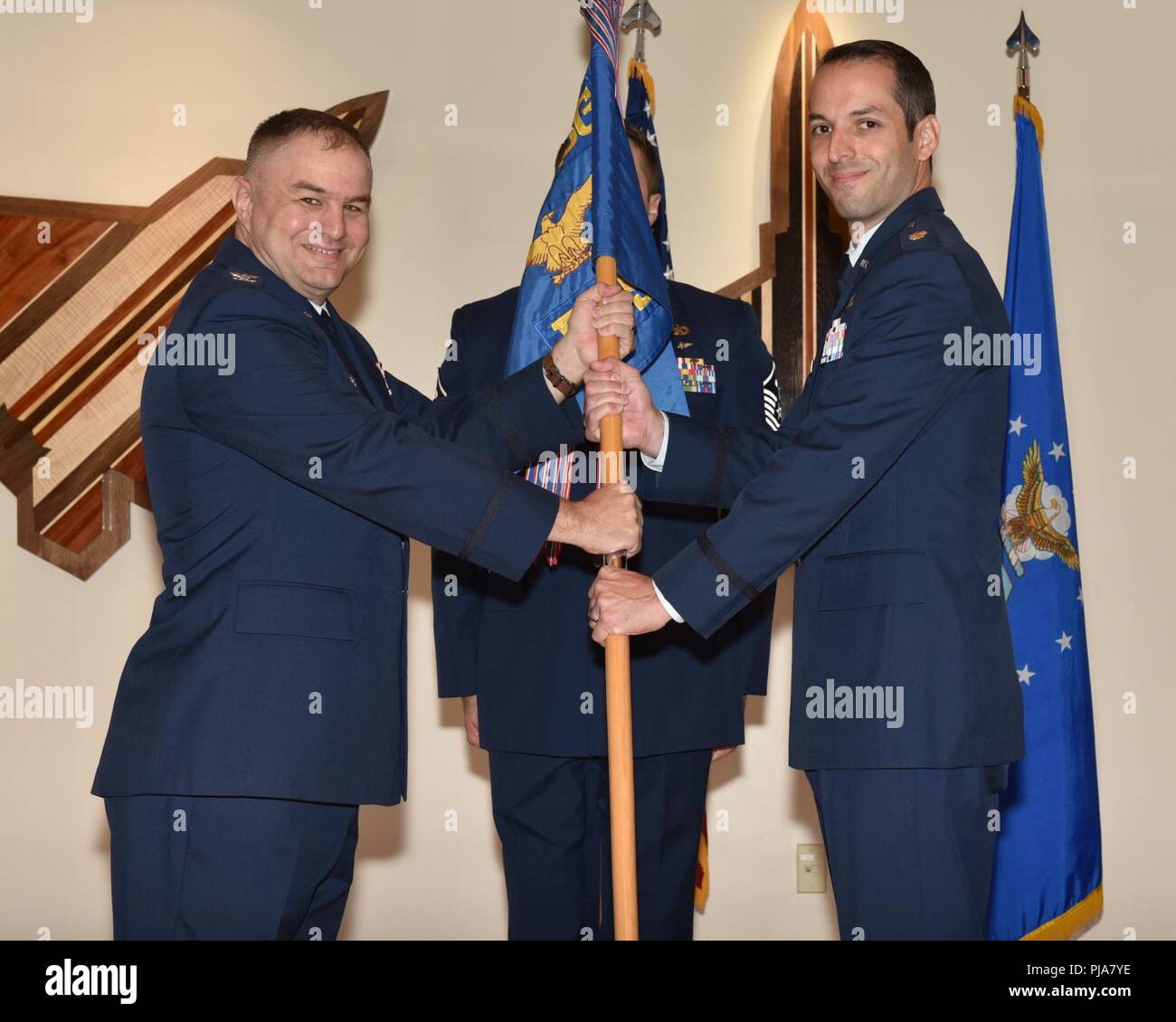 Stati Uniti Air Force Col. Matteo Jefson, 325Missione Gruppo supporto commander (sinistra), passa il cerimoniale guidon per il Mag. Jesse D. Calland, 325In Entrata vigore Support comandante dello Squadrone (destra), durante un cambiamento di comando cerimonia al Tyndall Air Force Base, Fla., 2 luglio 2018. Lo squadrone fornisce manodopera, personale e comunitario di supporto, dei servizi di istruzione e formazione per la 325Fighter Wing e 40 unità associate. Foto Stock