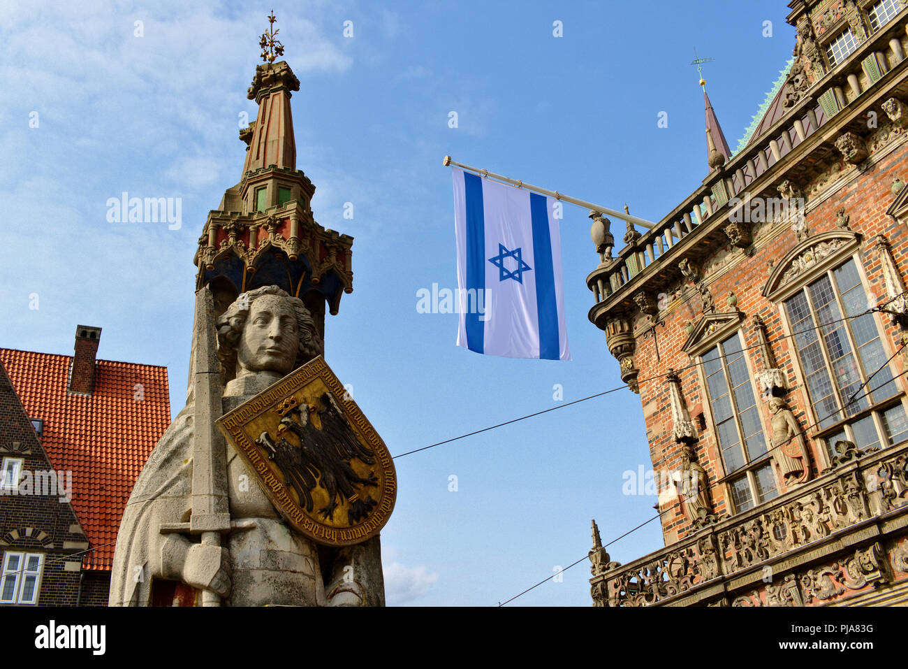 Bremen, Germania - bandiera Israeliana battenti dallo storico municipio in onore della prima visita di Israele dell ambasciatore di Germania con la statua di Roland Foto Stock