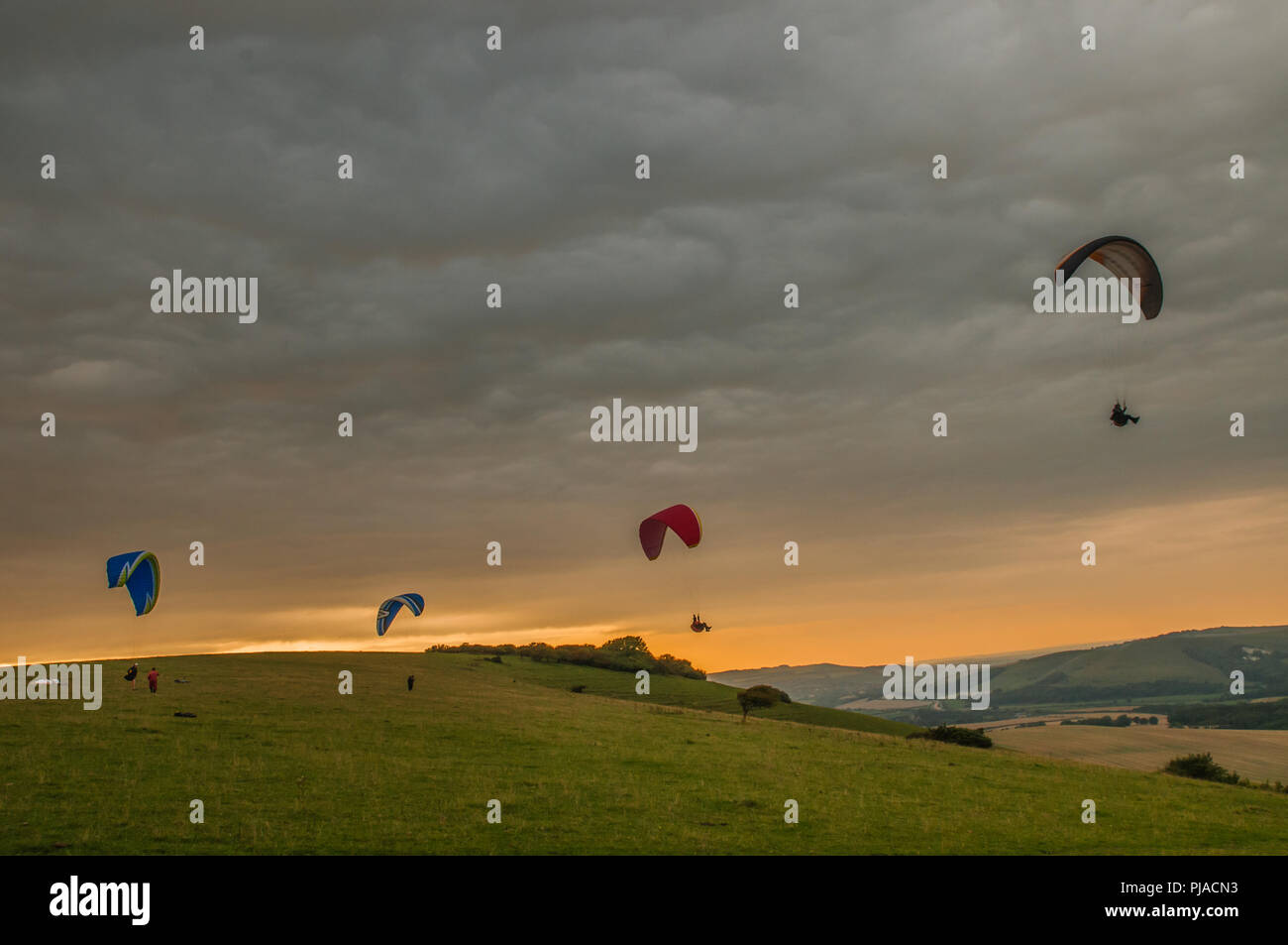 Firle, Lewes, East Sussex, UK..5 settembre 2018..piloti Di Parapendio sulla mistica campagna del Sussex nei pressi di Firle nei South Downs. Sun ha rotto la copertura del cloud nel tardo pomeriggio. . Foto Stock