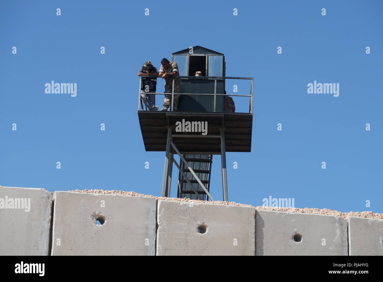 Rosh Hanikra, ISRAELE. 5th Settembre 2018. I membri delle forze armate libanesi si trovano all'esterno di una torre di guardia mentre guardano verso il basso dal lato libanese del confine lungo un muro di sicurezza alto sette metri costruito da Israele sul confine israelo-libanese vicino al Rosh HaNikra Crossing, noto anche come Ras al Naqoura Crossing. Il muro di cemento si estende dal Mar Mediterraneo ad ovest fino all'area intorno al Monte Hermon ad est. Foto Stock