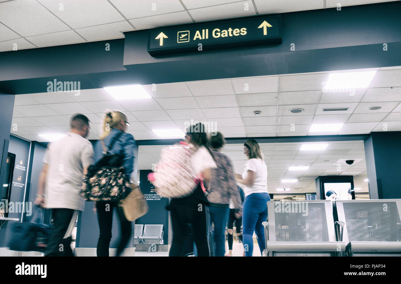 Persone che camminano verso le porte di partenza all'Aeroporto di Leeds Bradford. Inghilterra, Regno Unito Foto Stock