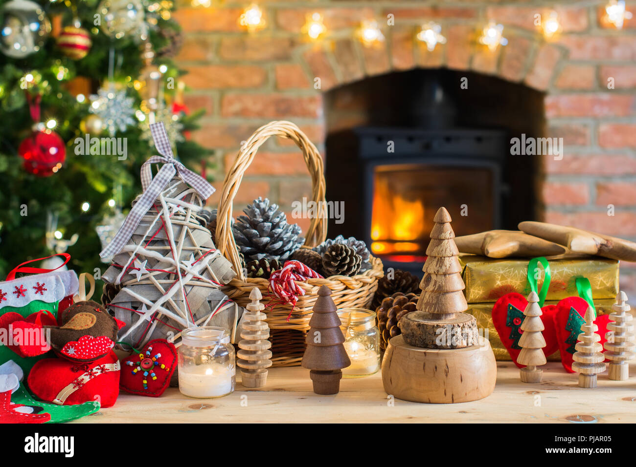 Natale fai da te: giocattoli in legno, decorazioni in feltro, presenta sul  tavolo, albero di Natale e camino con fuoco ardente sullo sfondo, il fuoco  selettivo Foto stock - Alamy