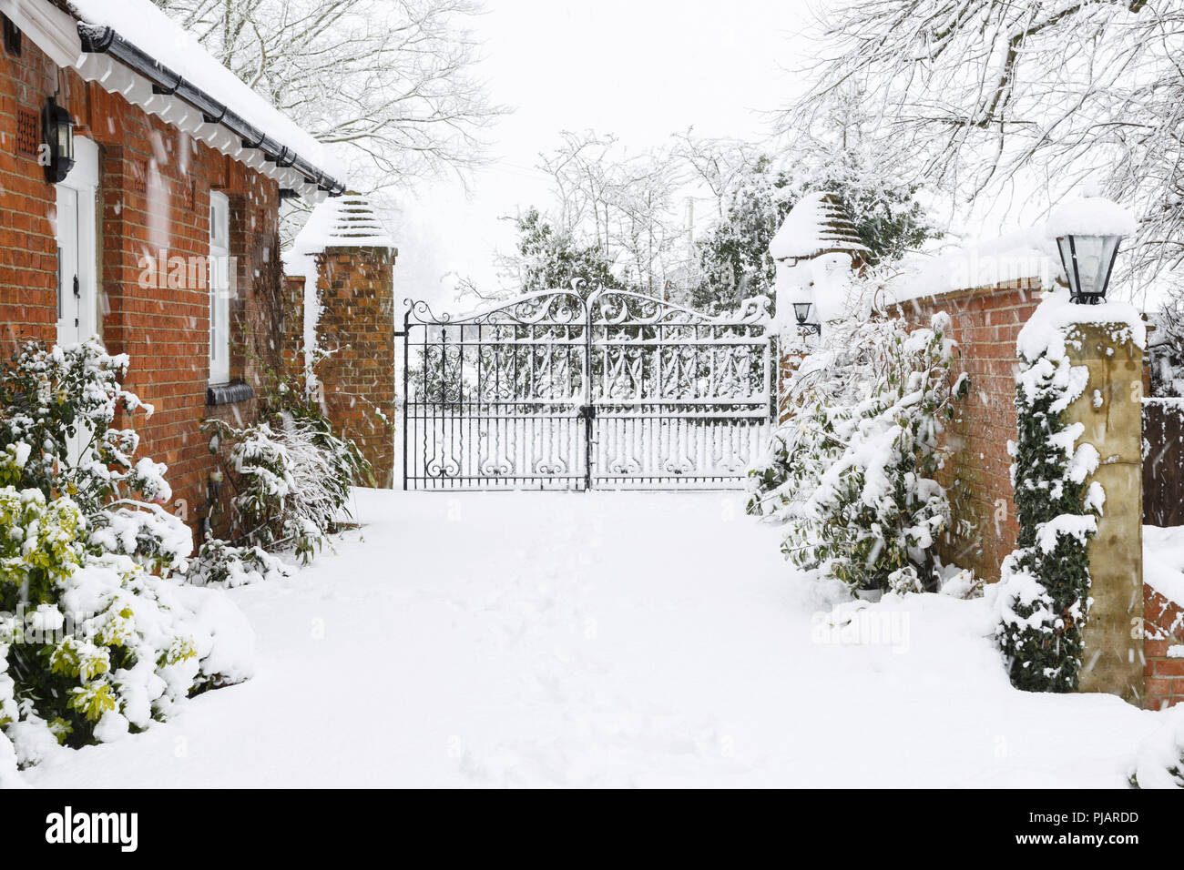 Ingresso alla casa vittoriana con ghisa cancelli con vialetto coperto di neve in inverno Foto Stock