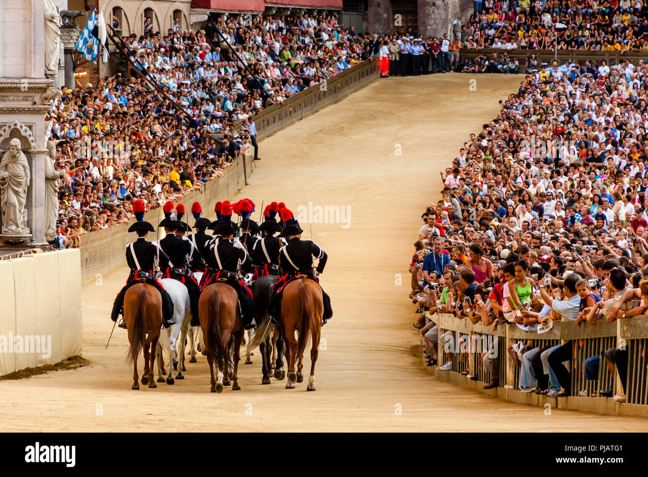 La sezione montata dei Carabinieri (forza di polizia) Preparare per correre intorno alla pista prima dell'inizio del Palio di Siena, Siena, Italia Foto Stock