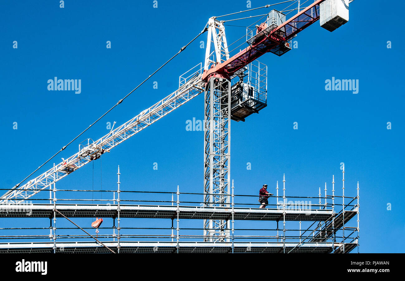 Gosford, Nuovo Galles del Sud, Australia - 4 agosto. 2018: costruzione e costruzione di aggiornamento progressi 114. Un gruppo di lavoro di gru a torre sulle nuove unità abitative edificio Foto Stock