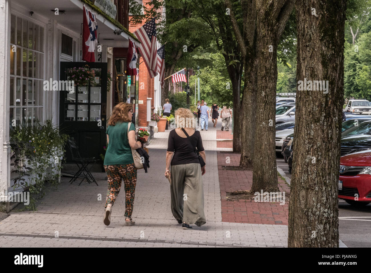 Due donne a piedi lungo la strada principale a Stockbridge, MA Foto Stock
