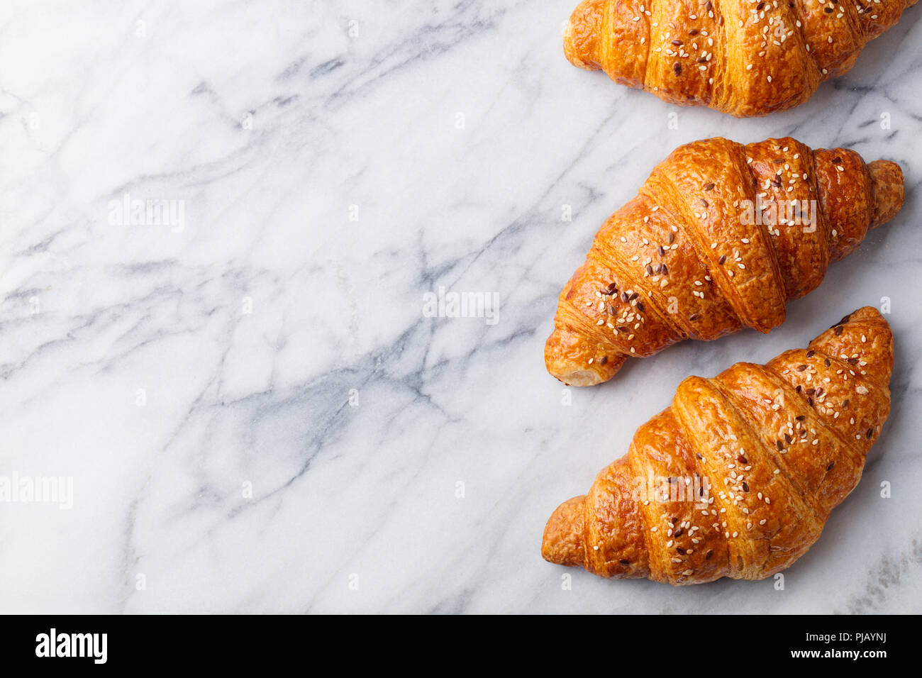 Croissant sulla tavola di marmo. Il francese tradizionale sfoglia. Vista dall'alto. Copia dello spazio. Foto Stock