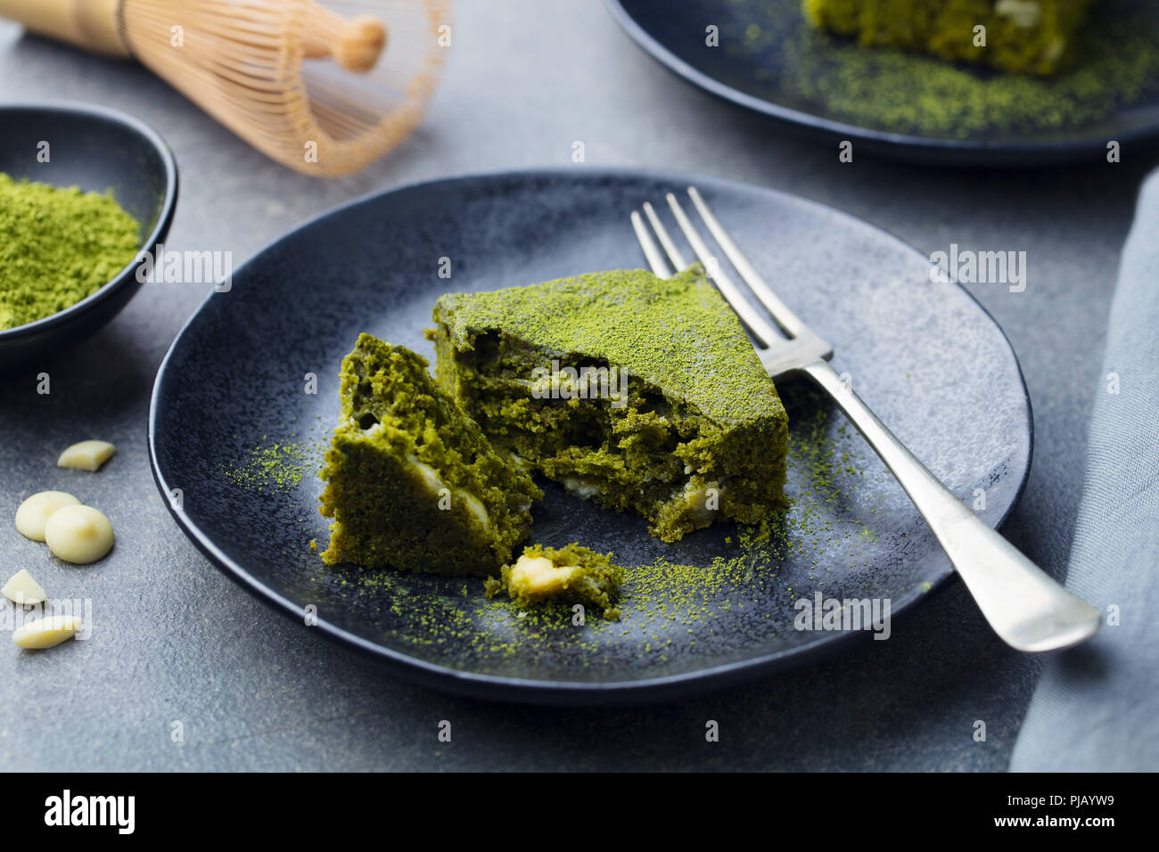 Tè verde Matcha torta, barre, brownie con il cioccolato bianco su una piastra. Sfondo grigio. Foto Stock