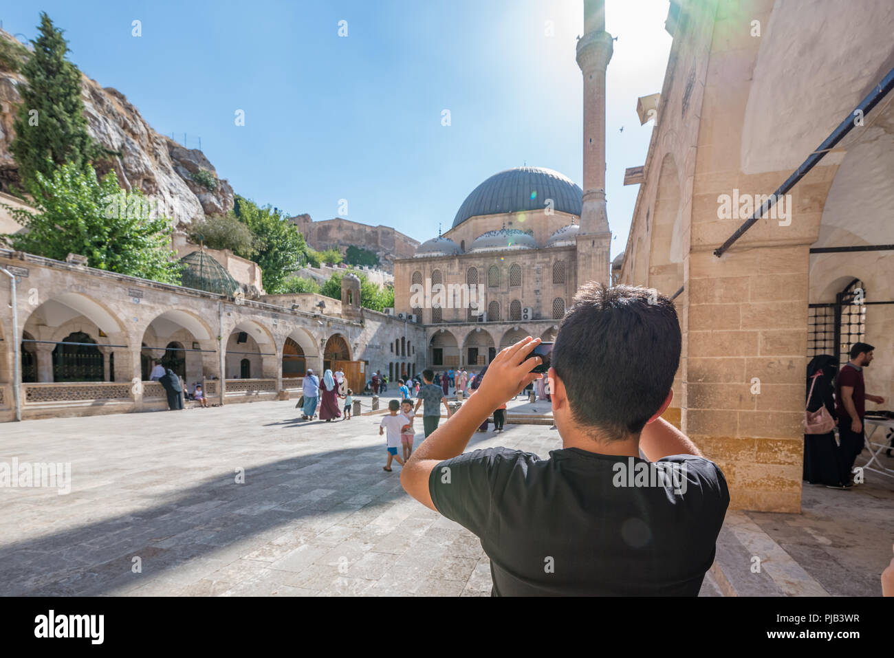 Persone non identificate a piedi al cortile di Mevlidi moschea di Halil,uno dei punti di riferimento di Sanliurfa,Turchia.19 Luglio 2018 Foto Stock