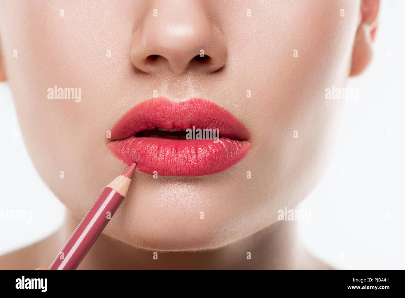 Vista parziale di donna rosa applicazione labbro matita, isolato su bianco Foto Stock