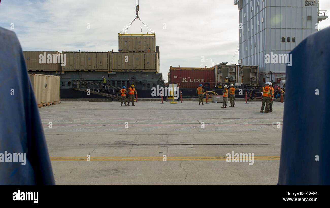 Velisti assegnati a Navy Cargo Handling battaglione (NCHB) 1, det. Guam, sul carico munizioni di lattine per una nave cargo presso la base navale di Guam, 2 luglio 2018. NCHB 1 det. Guam, assegnato al comandante, Task Force 75, è la marina è attivo solo dovere cargo handling battaglione, ed è rapidamente dispiegabile unità operativa della Marina Expeditionary comando di combattimento, in grado di caricare e scaricare le navi e gli aeromobili in tutte le condizioni climatiche e di condizioni di pericolo. Foto Stock