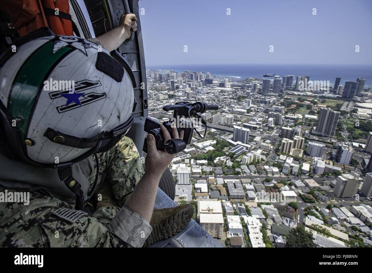 HONOLULU, Hawaii (2 luglio 2018) La comunicazione di massa specialista di seconda classe Litke Travis, assegnato al comandante, U.S. Terza flotta, le immagini riprese da un MH-60S Sea Hawk elicottero, assegnato al mare in elicottero Combat Squadron 8, durante il cerchio del Pacifico (RIMPAC) 2018 Esercizio, 2 luglio. Venticinque nazioni, 46 navi, cinque sommergibili, circa 200 aerei e 25.000 personale partecipano RIMPAC dal 27 giugno al 2 agosto in e intorno alle Isole Hawaii e la California del Sud. Il più grande del mondo marittimo internazionale esercitazione RIMPAC offre una singolare opportunità di formazione promuovendo e Foto Stock