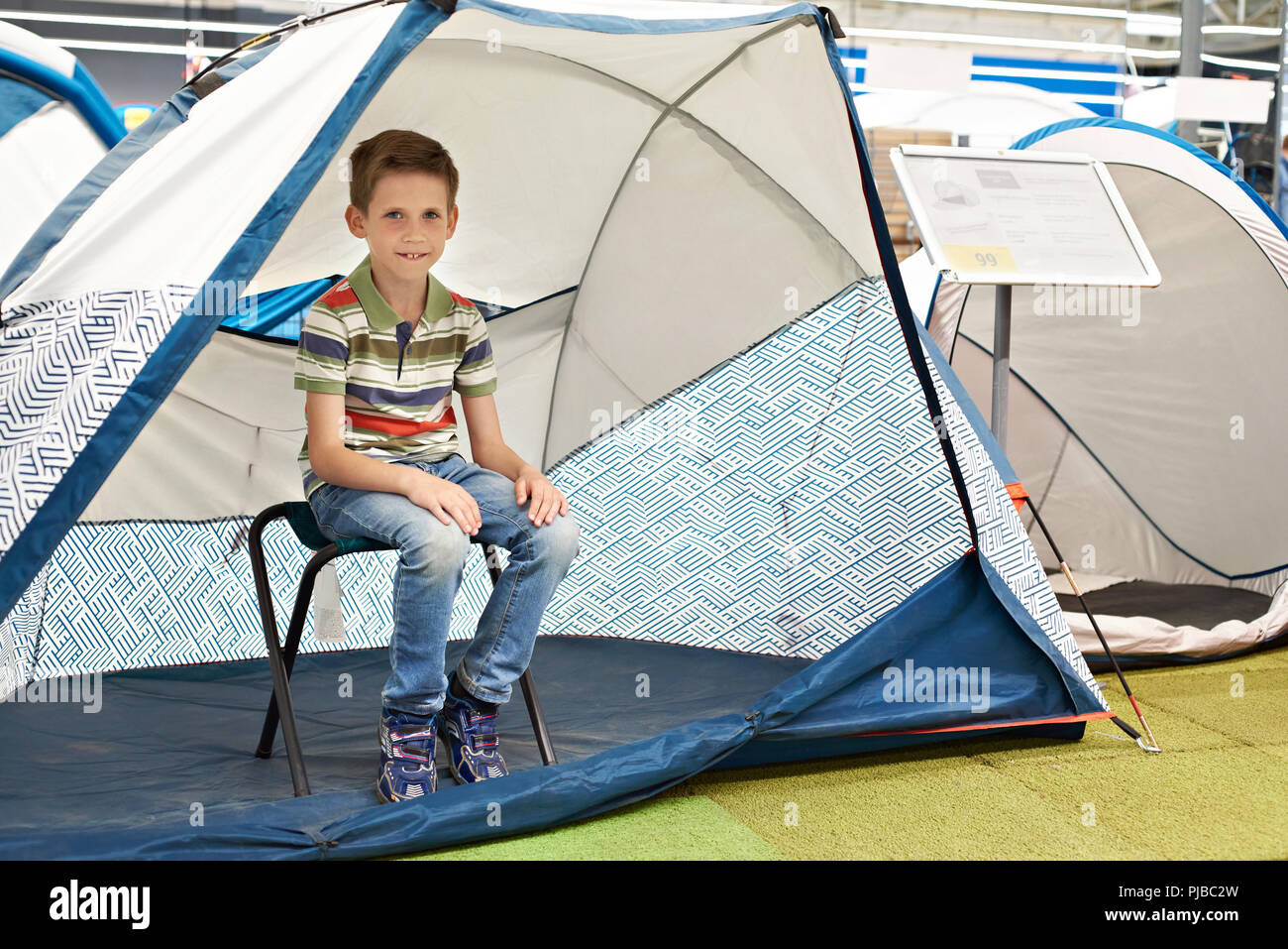 Ragazzo in una tenda turistica in un negozio di articoli sportivi Foto Stock