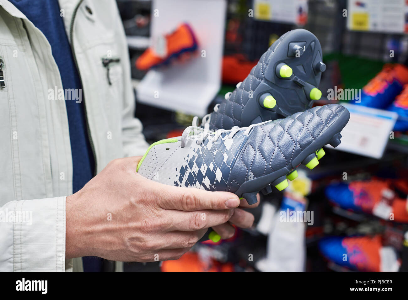 Le mani di un uomo con le scarpe da calcio in un negozio di sport Foto Stock