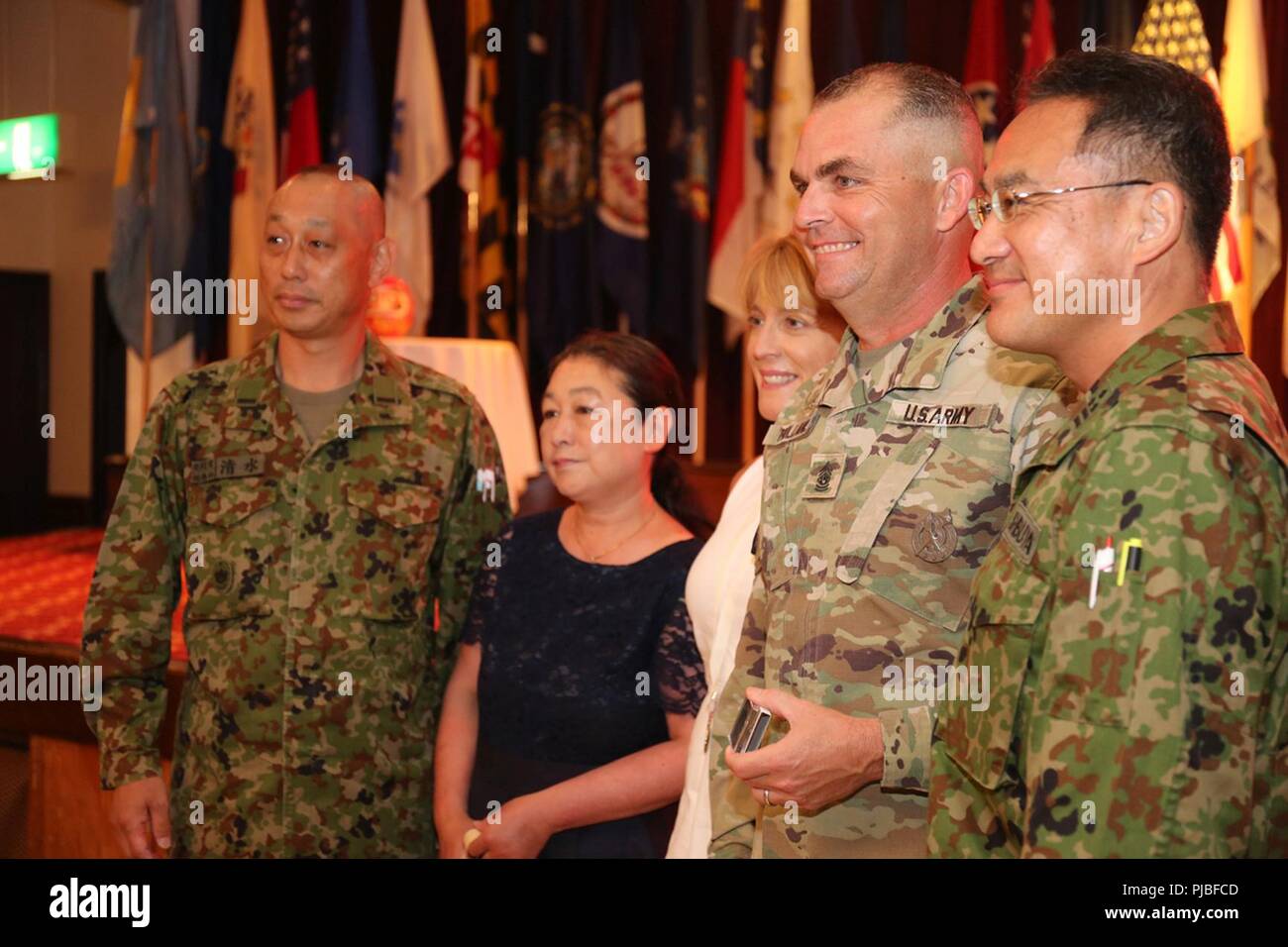 Negli Stati Uniti in uscita Presidio militare in Giappone il comando Sgt. Sarà importante Holland, e sua moglie, Wendy, pongono con ospiti giapponesi dopo l'Olanda di rinuncia di responsabilità cerimonia Luglio 11, 2018 al Camp Zama comunità Club. Holland ha detto a quelli raccolti che USAG il Giappone era la migliore assegnazione dei suoi 32 anni di carriera nell'esercito. Foto Stock