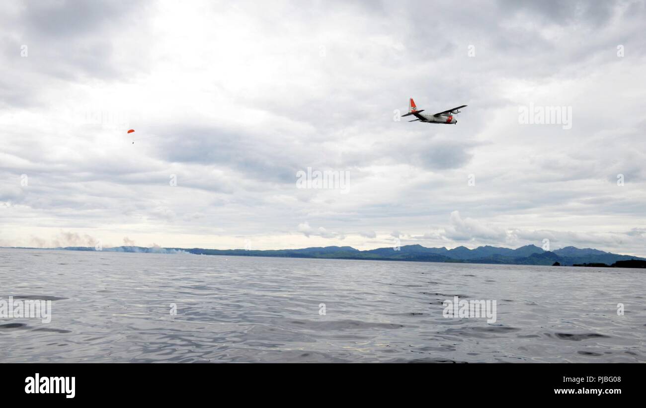 Una guardia costiera Stazione aria Kodiak HC-130 Hercules equipaggio scende le forniture per gli aiuti alla navigazione Team membri boatcrew a fini di formazione Luglio 10, 2018. Formazione di caduta è condotta per simulare dando le forniture ai superstiti durante un salvataggio. Stati Uniti Coast Guard Foto Stock