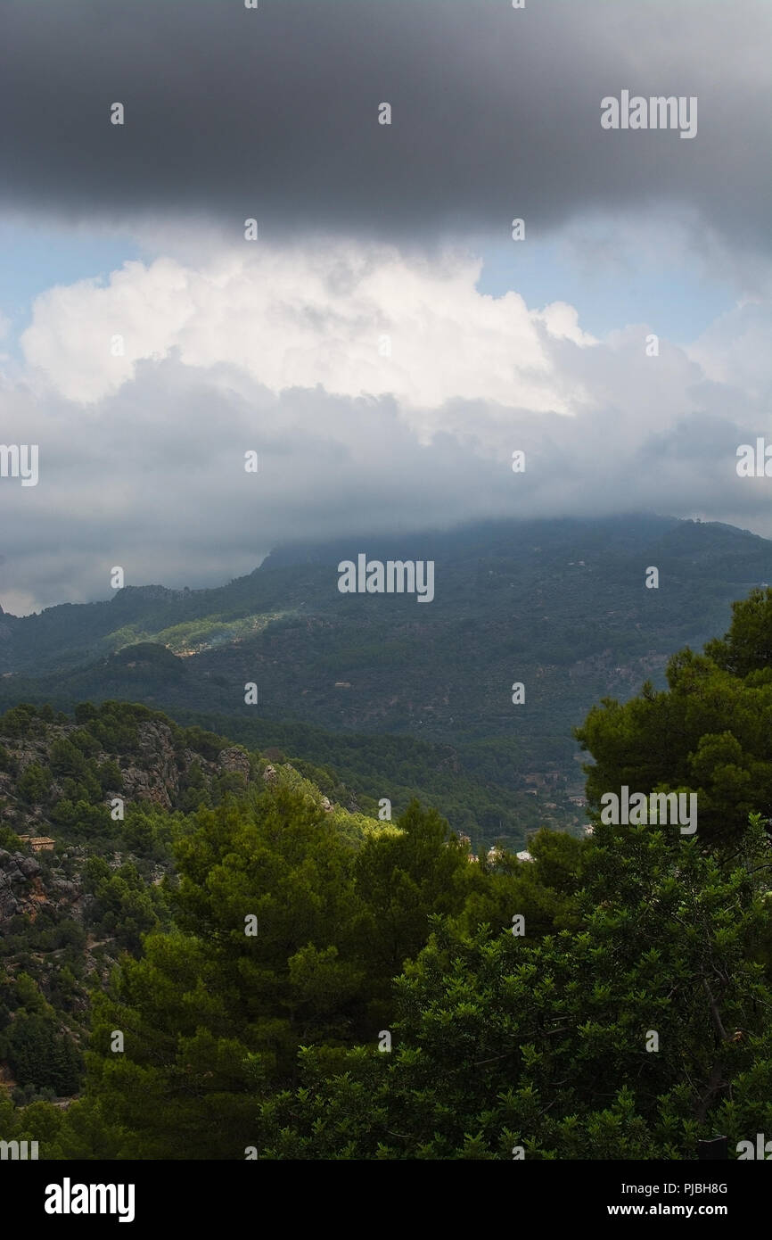 Maestoso paesaggio di montagna con sole e ombra e sfumature di verde prima di tempesta in agosto, Mallorca, Spagna. Foto Stock