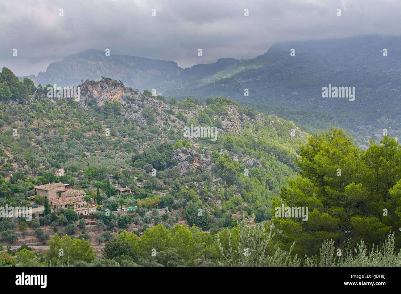 Maestoso paesaggio di montagna con sole e ombra e sfumature di verde prima di tempesta in agosto, Mallorca, Spagna. Foto Stock