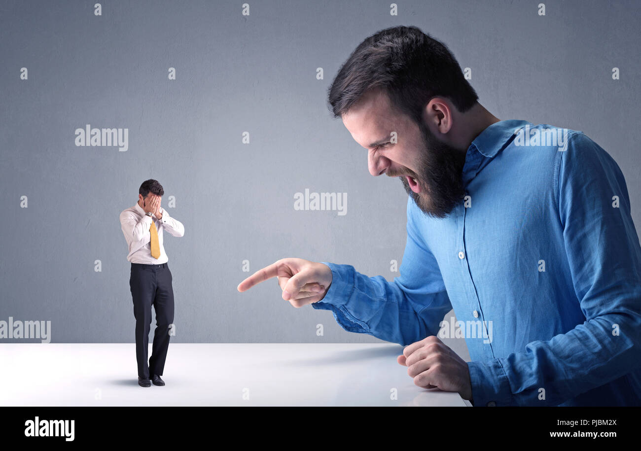 Giovane imprenditore professionale essendo arrabbiato con un altro imprenditore in miniatura Foto Stock