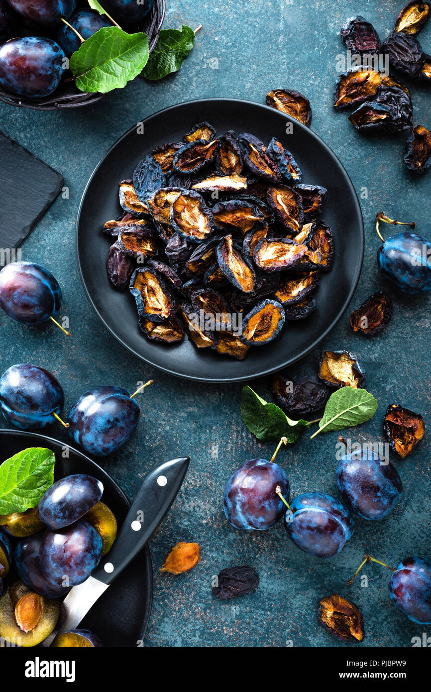 Essiccato di potare e prugne fresche con foglie Foto Stock