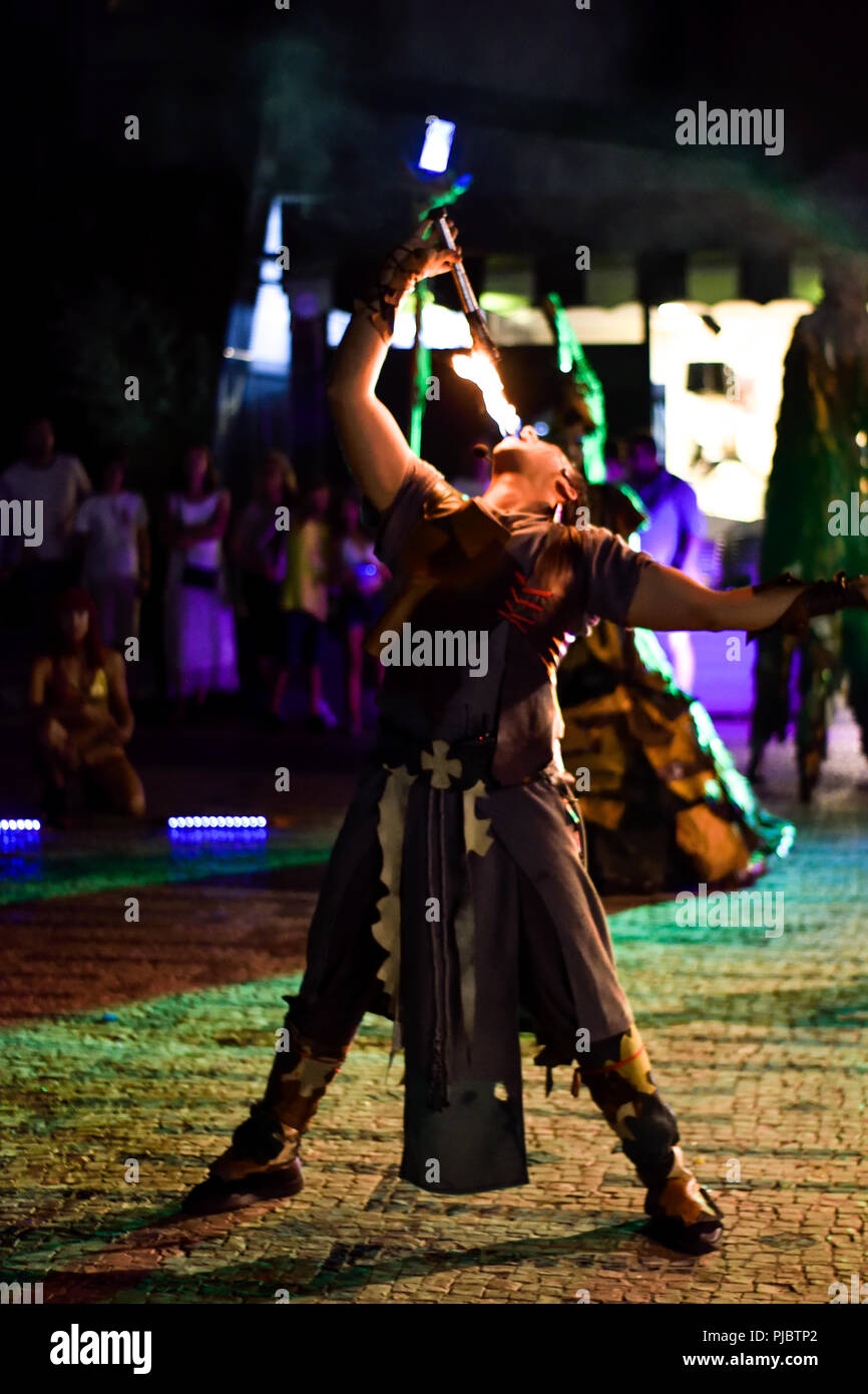 Dama de trapos spara artisti di strada, ingoiando il fuoco da un artista della torcia durante l'evento notturno della città Foto Stock