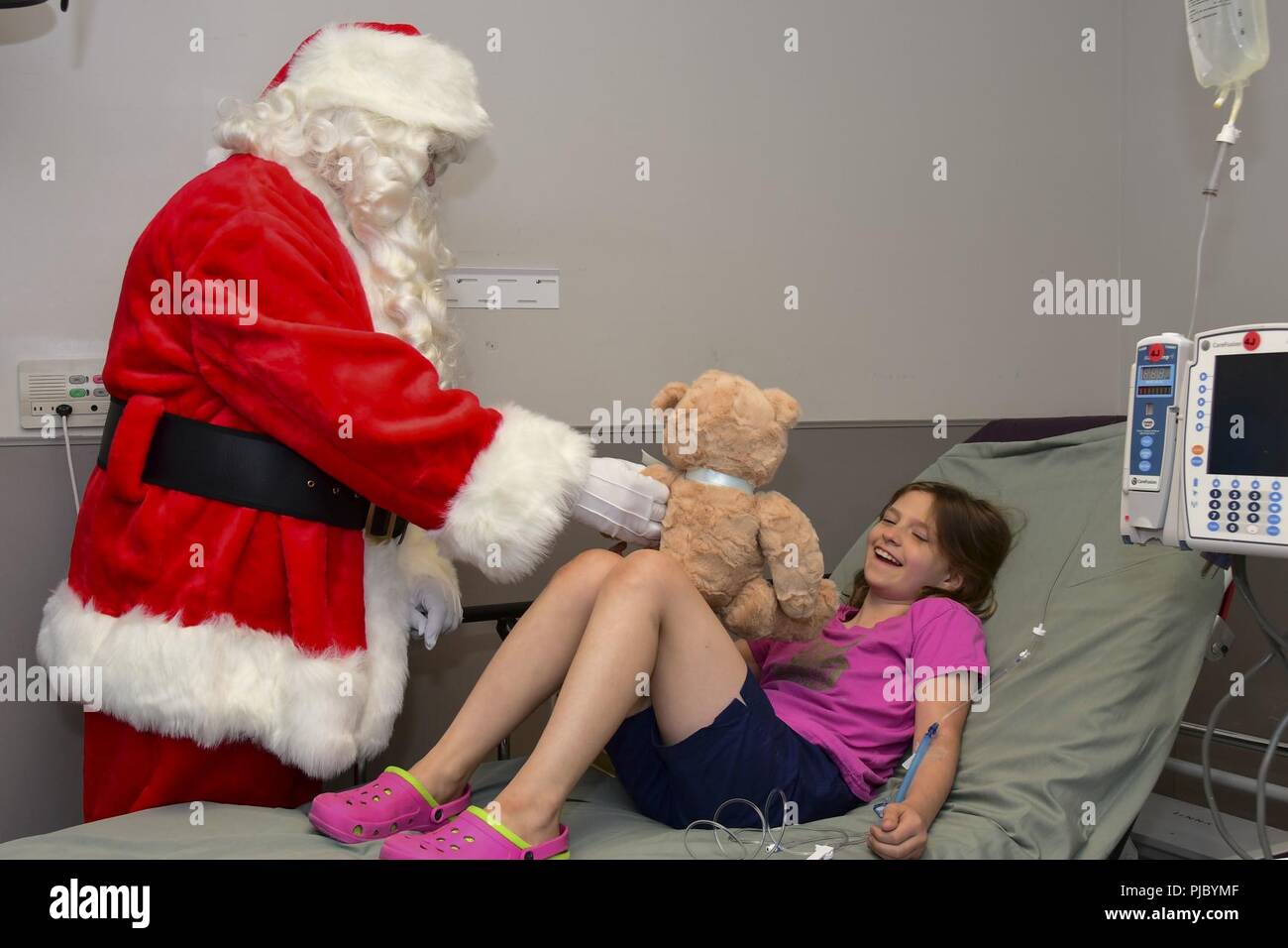 - Babbo Natale dà Alessandria un giocattolo durante il Rolling Thunder Natale in luglio. Queste moto club membri NMCP visita due volte l'anno, visitando i bambini in pediatria Ward, pediatrici di unità di cure intensive e sala di emergenza. Santa Claus mani presenta per ogni bambino riceve cure mediche. Foto Stock