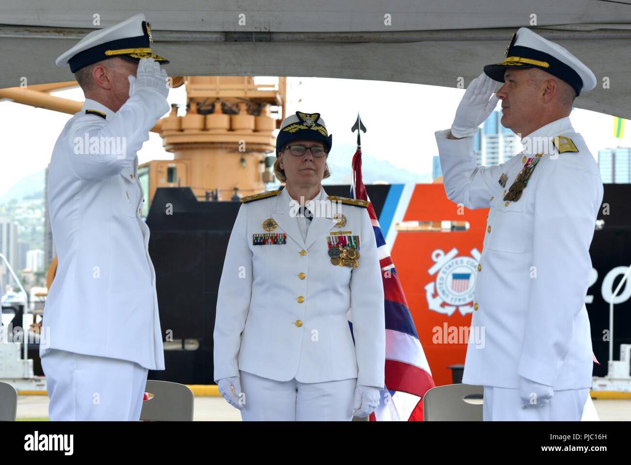 Adm posteriore. Kevin E. Lunday (sinistra) rilievi Adm posteriore. Brian K. Penoyer (destra) come comandante della quattordicesima Coast Guard District mentre Vice Adm. Linda L. Fagan (centro) presiede durante un cambio del comando cerimonia al Coast Guard Base Honolulu, luglio 19, 2018. Lunday precedentemente era stato Comandante della Guardia Costiera Cyber comando. Foto Stock