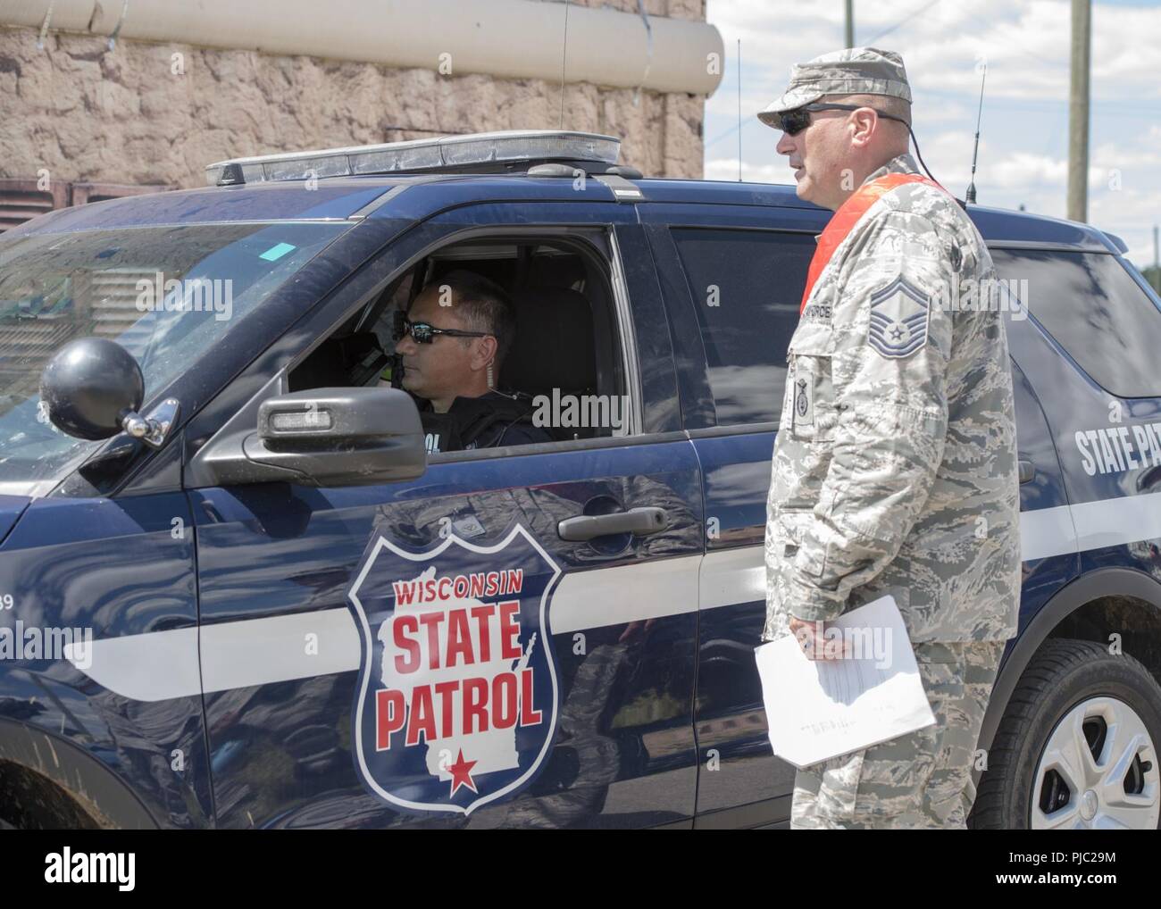 Trooper Jeremy Mcnulty con dello stato del Wisconsin, Patrol si prepara a scortare un calo di alimentazione veicolo Luglio 17, 2018 durante il patriota Nord esercitare sulla Fort McCoy, Wisconsin. Patriot è un nazionale di operazioni di disaster-risposta esercizio di formazione condotta dalla Guardia Nazionale di unità di lavoro federali, statali e locali di gestione delle emergenze le agenzie e i soccorritori. Foto Stock