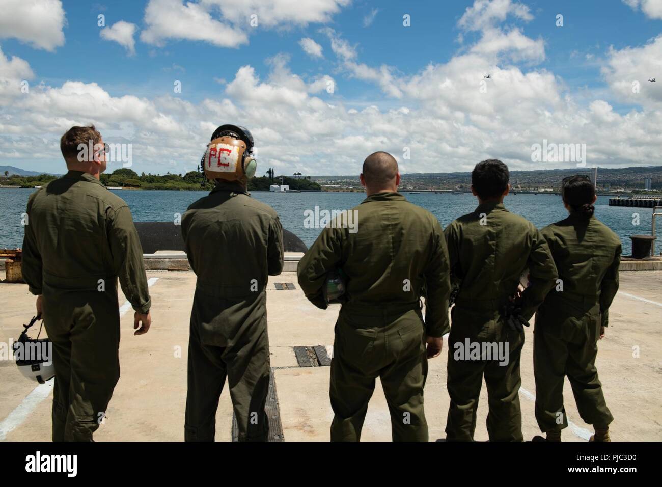 PEARL HARBOR (Luglio 20, 2018) Marines servendo con mezzo marino Tilt-squadrone del rotore 265 (VMM-265) guarda la MV-22 Asprì sorvolare la USS Arizona Memorial in rotta per Marine Corps base Hawaii (MCB Hawaii). VMM-265 sta assistendo con il velivolo di transizione da Okinawa, in Giappone per MCB Hawaii. Foto Stock