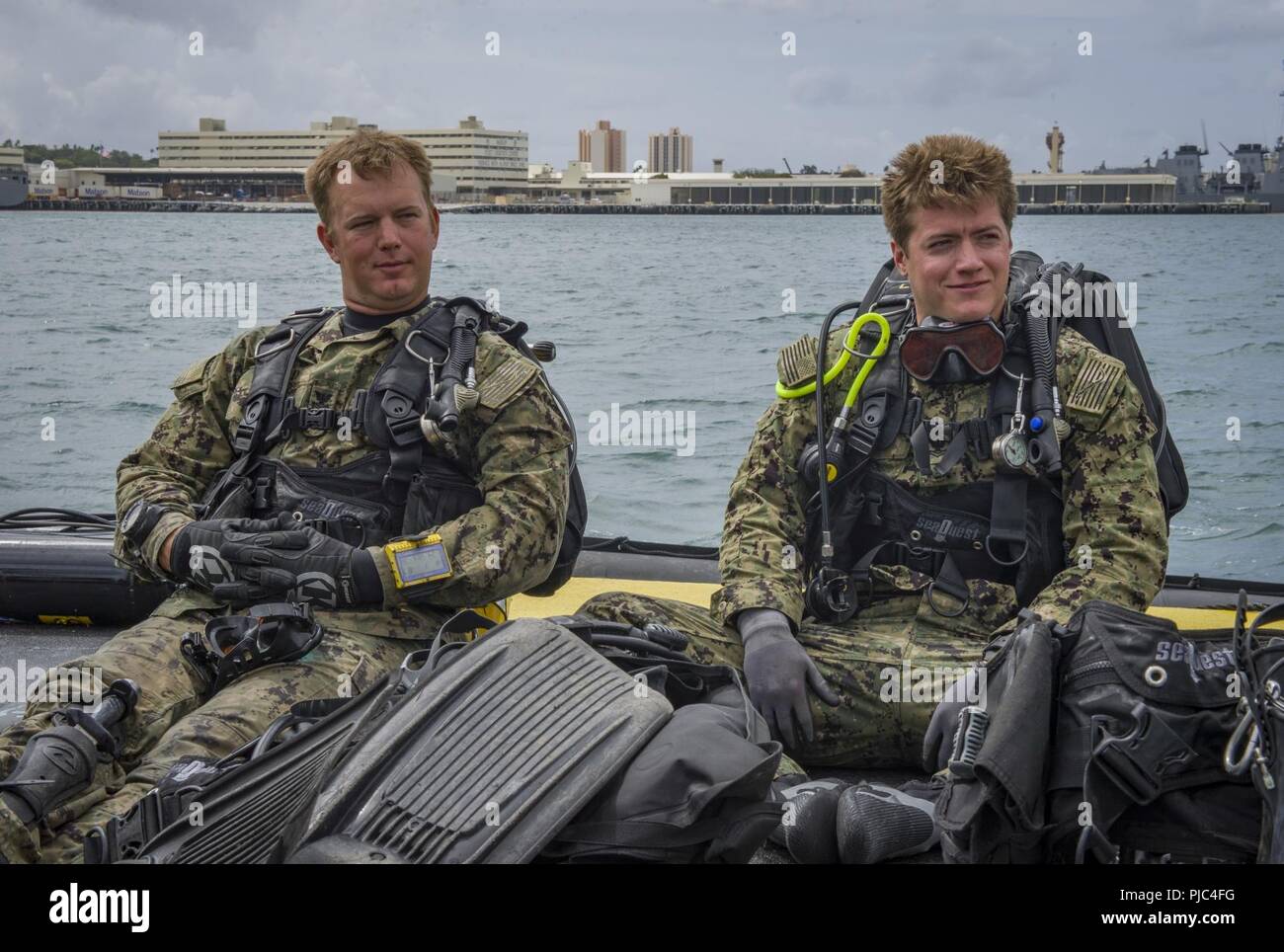 BASE COMUNE DI PEARL HARBOR-HICKAM, Hawaii (Luglio 13, 2018) - Builder 1. Classe lancia Fairchild, sinistra e il Navy Diver 2a classe Casey Ras, entrambi assegnati a Navy strutture di ingegneria e Expeditionary Warfare Center, prepararsi a immersione la USS Arizona Memorial per ispezionare i suoi punti di ancoraggio durante il cerchio del Pacifico (RIMPAC) Esercizio, luglio 13. Venticinque nazioni, 46 navi, cinque sommergibili, circa 200 aerei, e 25.000 personale partecipano RIMPAC dal 27 giugno al 2 agosto in e intorno alle Isole Hawaii e la California del Sud. Il più grande del mondo marittimo internazionale esercitazione RIMPAC pro Foto Stock