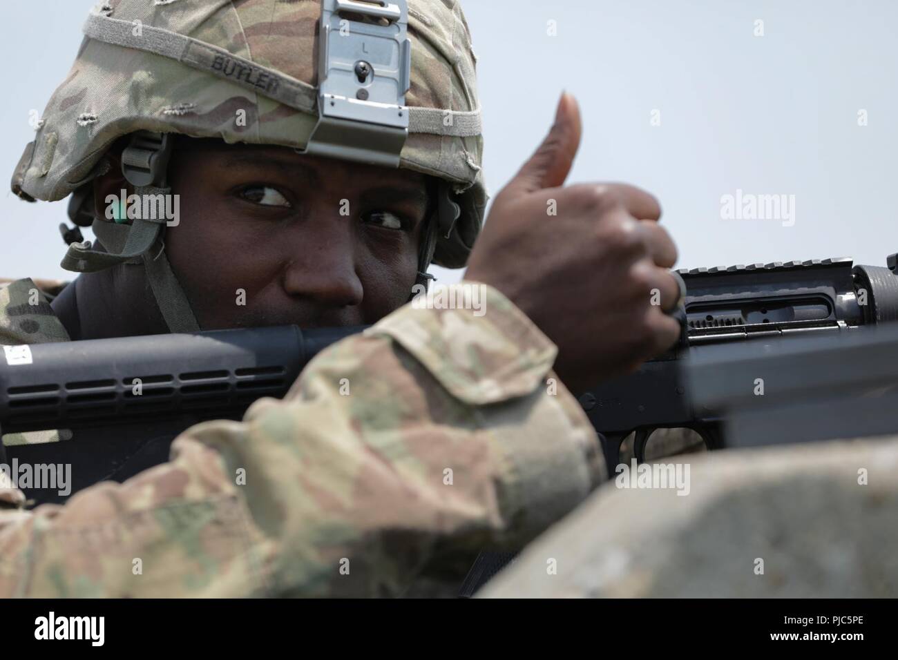 Stati Uniti Il personale dell'esercito Sgt. Duane Butler dà un pollice fino alla gamma di segnalazione di controllo egli è pronto a far fuoco il M4A1 carbine in corrispondenza di un intervallo durante l'esercito Materiel del comando guerriero migliore concorrenza 9-11 luglio 2018, presso il Camp Atterbury, Indiana. Durante i tre giorni di gara, i soldati sono stati testati su base e avanzate attività di guerriero e trapani, si trovano di fronte a sfide prova la loro forza fisica e mentale. Foto Stock