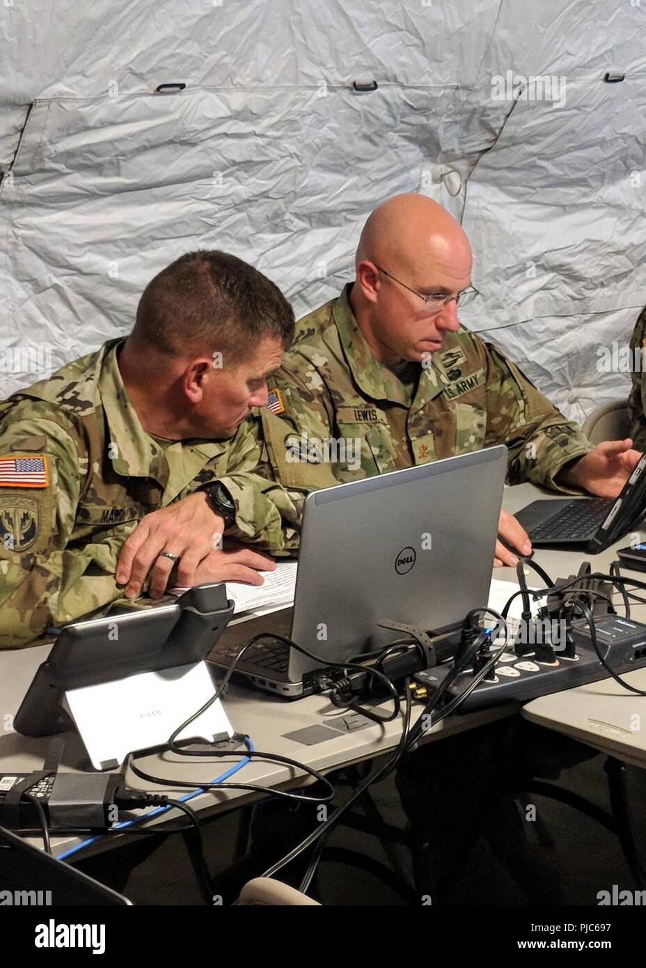 BASE COMUNE DI PEARL HARBOR-HICKAM, Hawaii (Luglio 16, 2018) Sgt. Grandi James Marsh appare come il Mag. Scott Lewis lavora su una valutazione del 351 gli affari civili del Comando Militare civile Operations Center (CMOC). 84Comando di formazione valutate le capacità del 351 soldati in impostazione e funzionamento di un CMOC mentre partecipa all'assistenza umanitaria e di soccorso in caso di catastrofe esercizio durante il cerchio del Pacifico (RIMPAC) esercizio. Venticinque nazioni, 46 navi, cinque sommergibili e circa 200 aerei e 25.000 personale partecipano RIMPAC dal 27 giugno al 2 agosto e arou Foto Stock