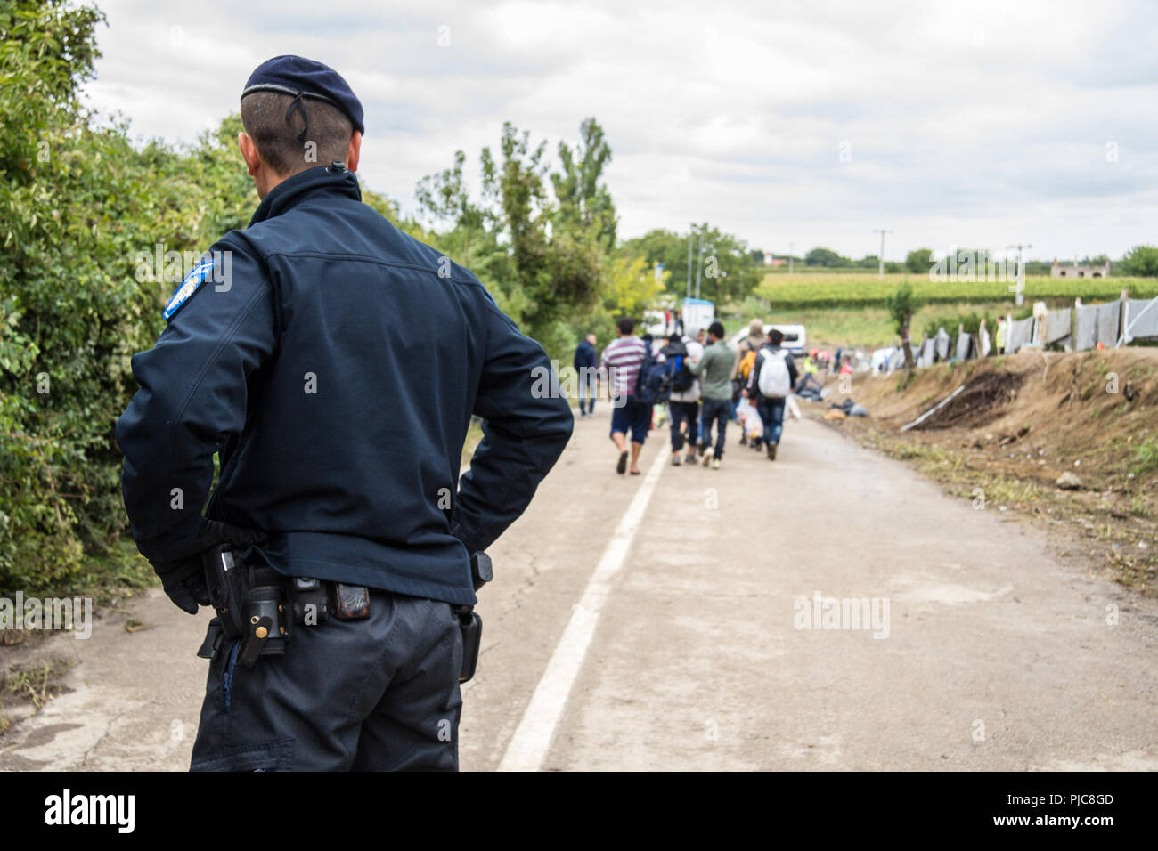 BERKASOVO, SERBIA - Settembre 27, 2015: Croato poliziotto guardando micrants attraversando la Serbia Croazia confine in Berkasovo Bapska, sui Balcani Foto Stock