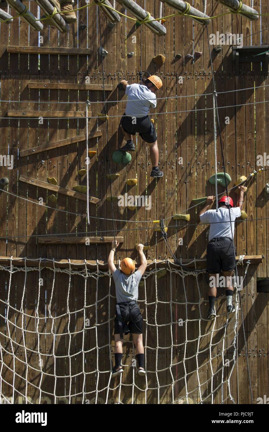 I candidati in Sunburst sfida della gioventù dell Accademia Classe 22 Firehawks plotone lavorare il loro modo attraverso un intricato sistema di corda ostacoli mentre l'ascendente di una zip line finish, luglio 19, 2018 all'Orange County ropes course di Anaheim, in California. Le funi corso offre ai candidati la possibilità di spingere se stessi sia mentalmente e fisicamente, per costruire la fiducia e di iniziare a lavorare come un team mentre è ancora in fase di acclimatazione della sfida del programma. Foto Stock