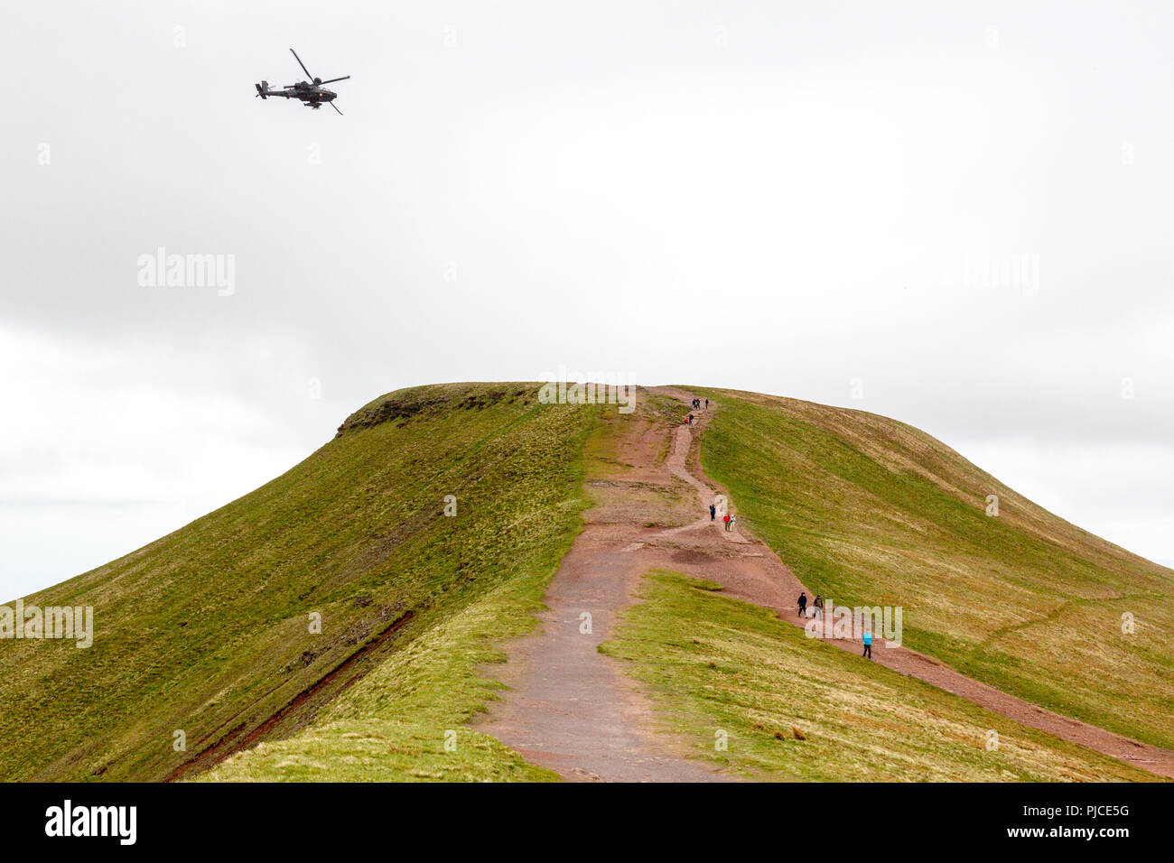 Un elicottero Apache passa su Pen-y-vertice della ventola - Il punto più alto sul Brecon Beacons e nel sud della Gran Bretagna, Powys, Wales, Regno Unito Foto Stock