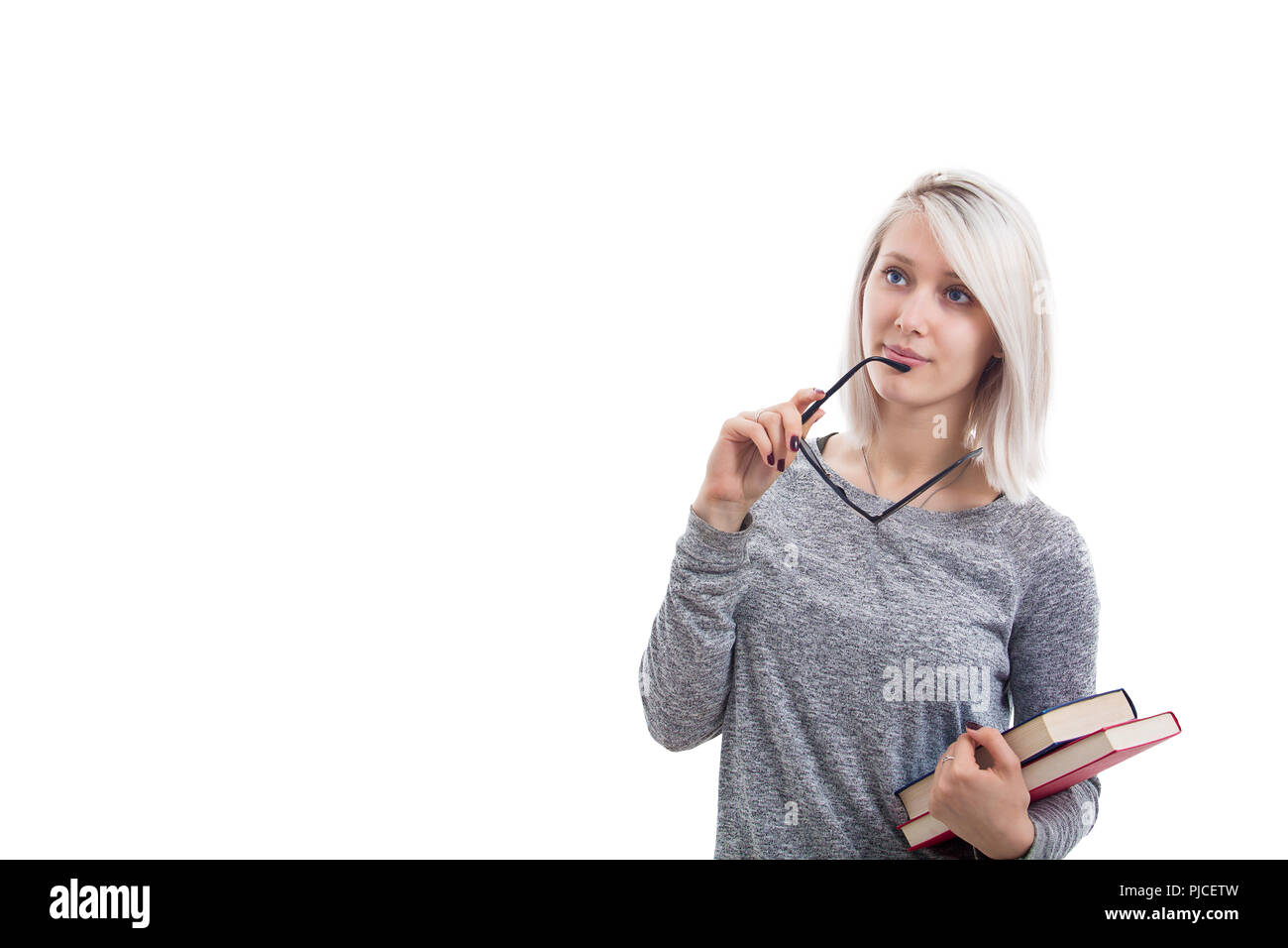 Ragazza intelligente con libri in una mano e gli occhiali in un'altra. Pensando studente isolato su sfondo bianco. Foto Stock