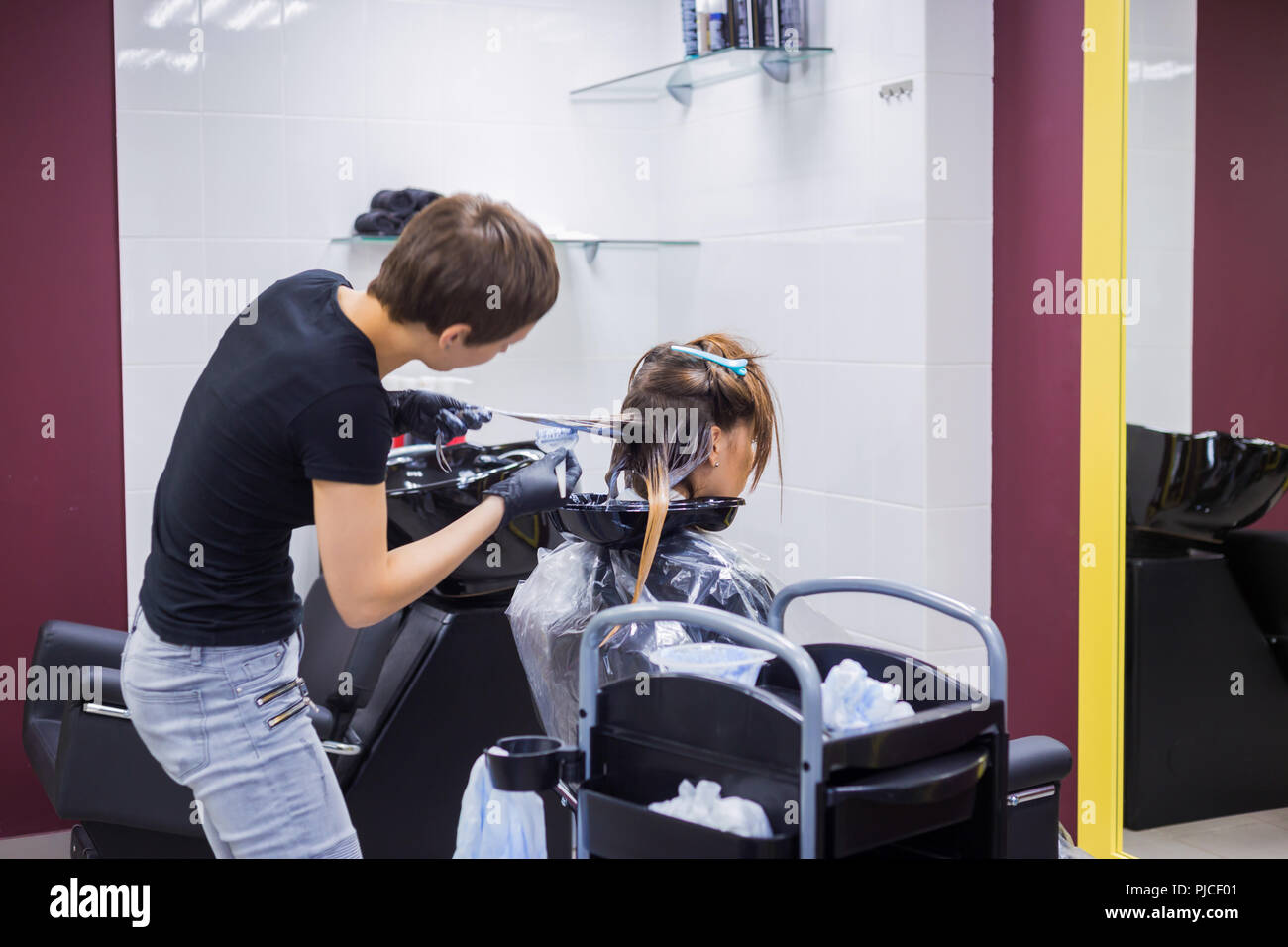 Parrucchiere professionale colorazione dei capelli della donna client presso studio Foto Stock